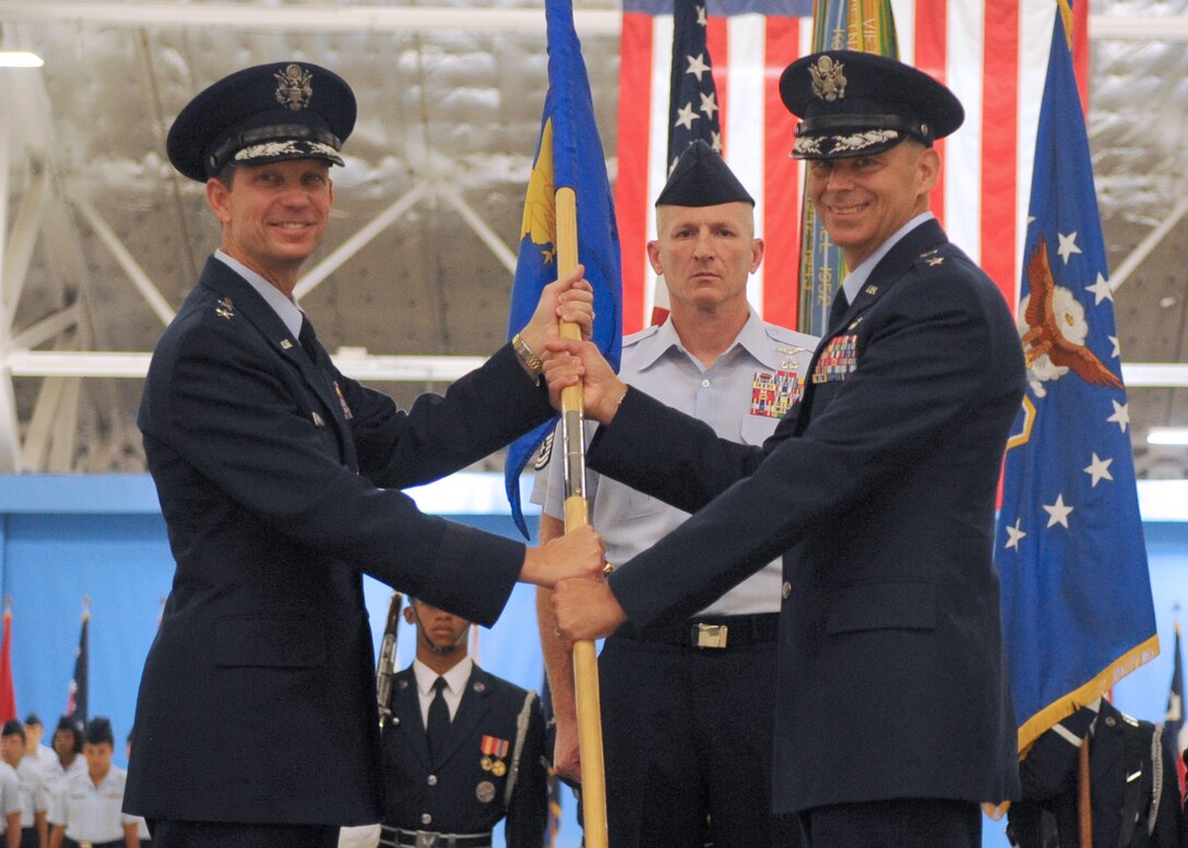 JOINT BASE ANDREWS, Md. -- Major Gen. Darrell Jones, Air Force District of Washington commander, passes the 79th Medical Wing guidon to Maj. Gen. Gerard A. Caron, 79th Medical Wing commander, during the change of command Sept 24. (U.S. Air Force photo by Senior Airman Melissa Brownstein)