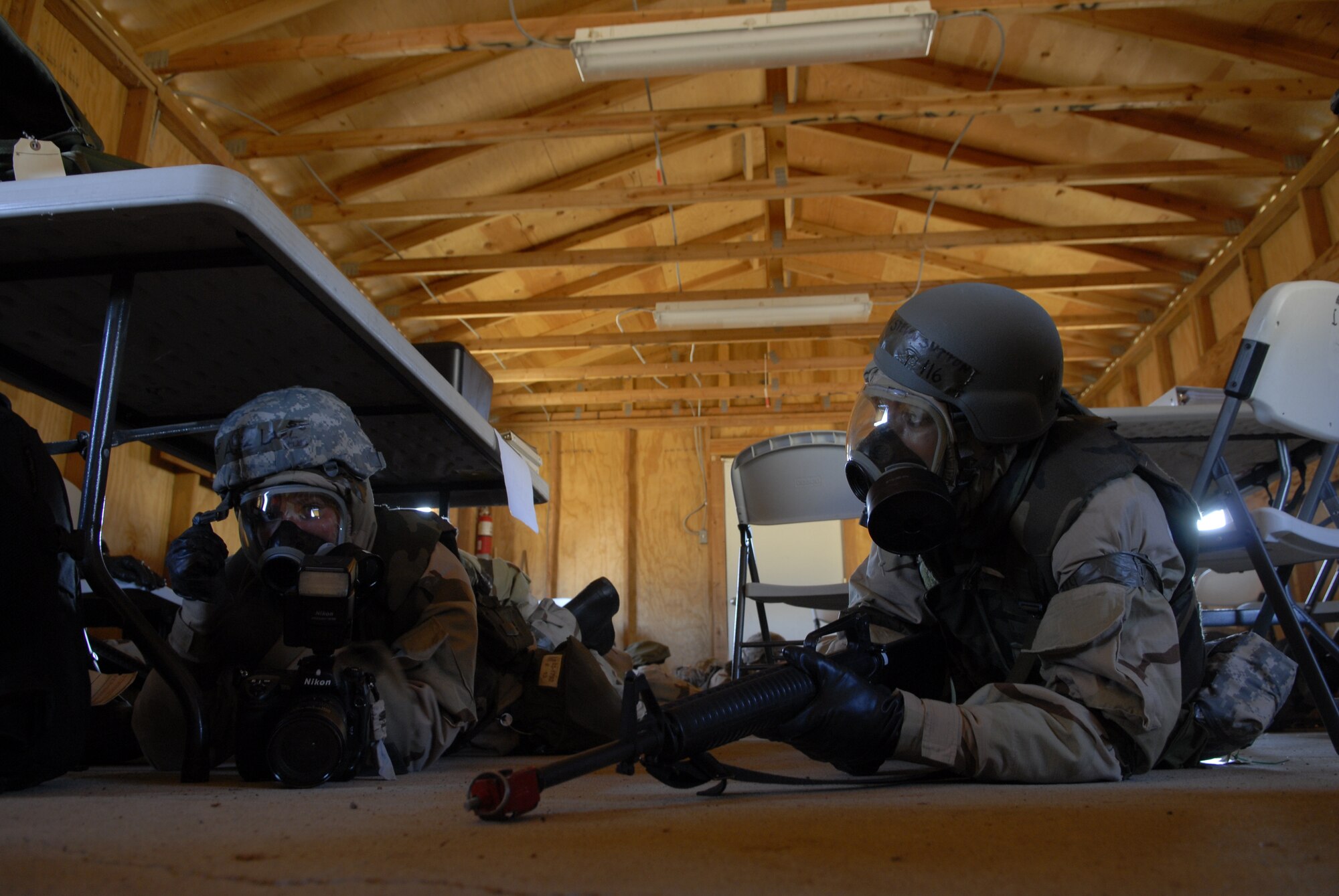 VANDENBERG AIR FORCE BASE, Calif. -- Airman 1st Class Lael Huss, 30th Space wing member, and Airman 1st Class Steven Sutton, 30th Comptroller Squadron member, protect themselves during a simulated mortar attack during the Northstar exercise here Thursday, Sept. 23, 2010.  Team V members practiced skills that they will use in a deployed environment.  (U.S. Air Force photo/Senior Airman Andrew Satran) 

 

 

 

 
 

 