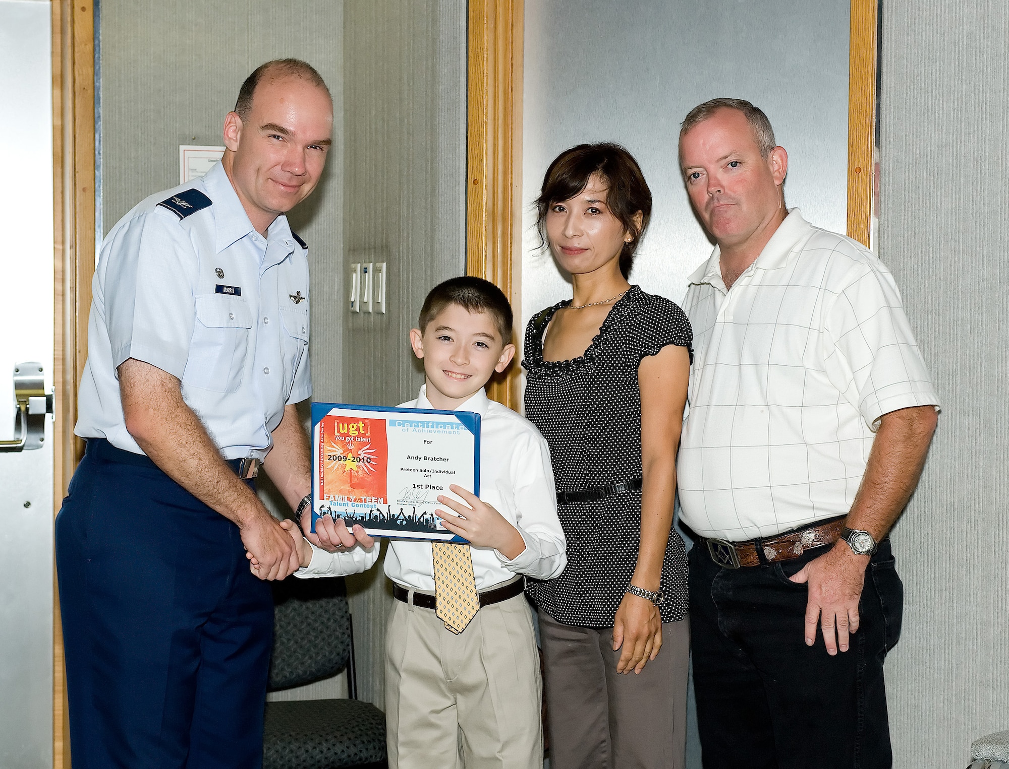 Col. Manson Morris, 436th Airlift Wing commander, shakes hands with Andrew Bratcher as he receives his award for placing first in the Year of the Air Force Family "You Got Talent" competition. Andrew, 11, was with his parents, Perry and Noriko Bratcher at the Presentation at Dover Air Force Base, Del., Sept. 29, 2010. Andrew won the award for placing first in the solo instrumental category age nine to 12 for the Air Force-level competition. (U.S. Air Force photo by Jason Minto/Released)