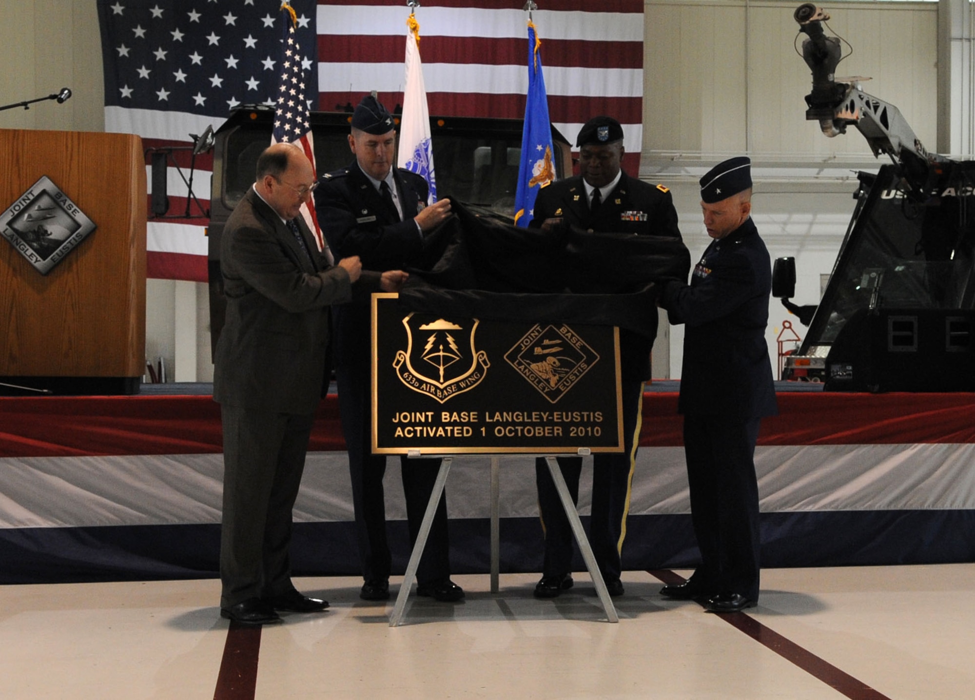 LANGLEY AIR FORCE BASE, Va - Mr. Russell B. Hall, Director of Northeast Region Installation Management Command, Col. Donald E. Kirkland, 633d Air Base Wing commander, Col. Reggie L. Austin, 633 ABW vice commander, and Brig. Gen. Dave Howe, Director of Air Combat Command Installations and Mission Support, unveil the Joint Base Langley-Eustis plaque during a ceremony declaring Full Operational Capability for Joint Base Langley-Eustis at Langley Oct. 1.  The purpose of joint basing is to reconfigure Department of Defense infrastructure into one where operational capacity is optimized for warfighting capability and efficiency. (U.S. Air Force Photo/Staff Sgt. Christina M. Styer)(RELEASED)  