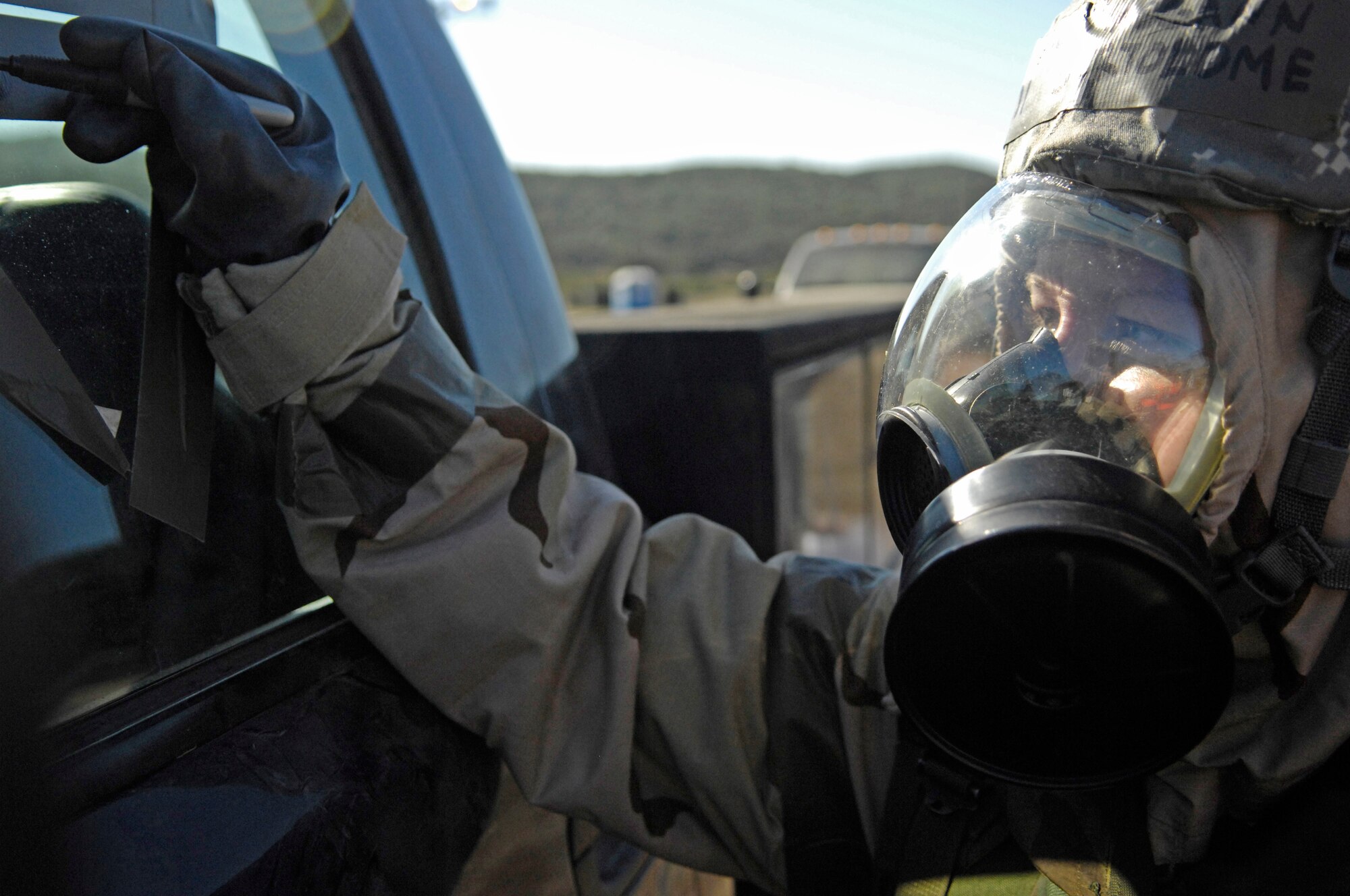 VANDENBERG AIR FORCE BASE, Calif. – Wearing her mission oriented personal protection gear, Airman 1st Class Meagann Bartolome, a 30th Space Wing Judge Advocate paralegal, marks an improvised chemical warning sign during Northstar exercise conducted by the base here Friday, Sept. 24, 2010. The Northstar exercise is designed to simulate wartime deployment scenarios including live fire, mortar attacks and chemical warfare. (U.S. Air Force photo/Airman 1st Class Lael Huss)