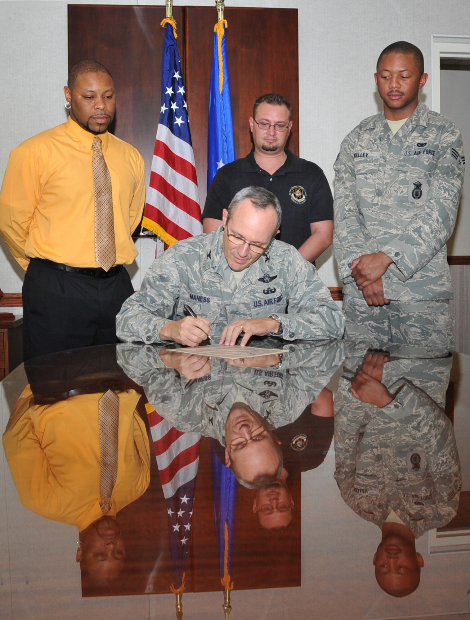 Col. Robert L. Maness, 377th Air Base Wing commander, signs a proclamation making October 2010 Wounded Warrior month at Kirtland Air Force Base. Observing are three wounded warriors. From left,  Albert Frisbey, 377th Logistics Readiness Squadron, Charles Wyatt, Air Force Nuclear Weapons Center, and Senior Airman Eddy Kelley, 377th Security Forces Squadron.  U.S. Air Force Photo by Elizabeth Martinez.