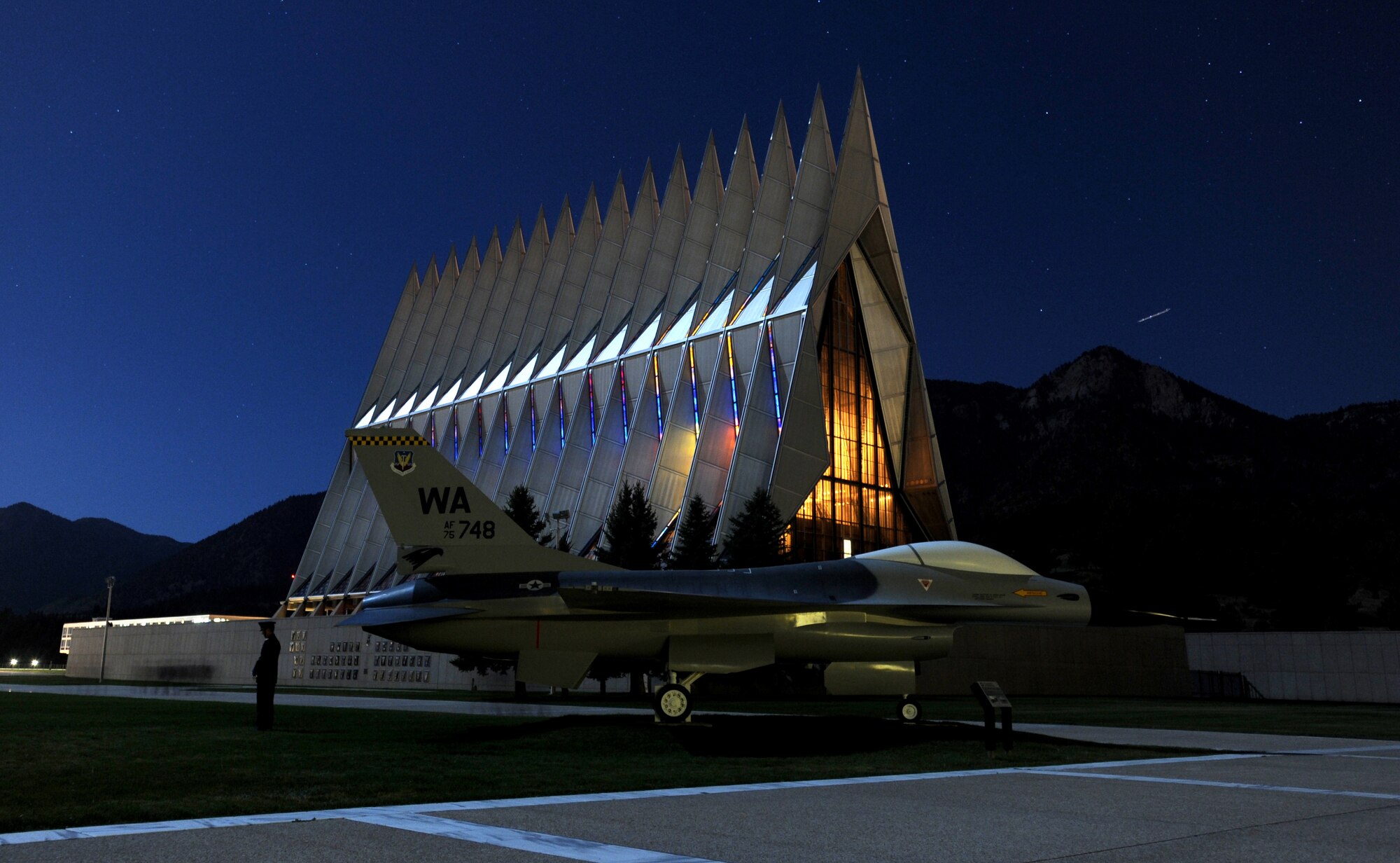 An Air Force Academy cadet mourns Cadet 1st Class Marc Henning in the Terrazzo during a Taps ceremony Sept. 21, 2010, while a meteor shoots over Eagle Peak in the background. Cadet Henning, a native of Crossville, Ill., was 22. (U.S. Air Force photo/Johnny Wilson)