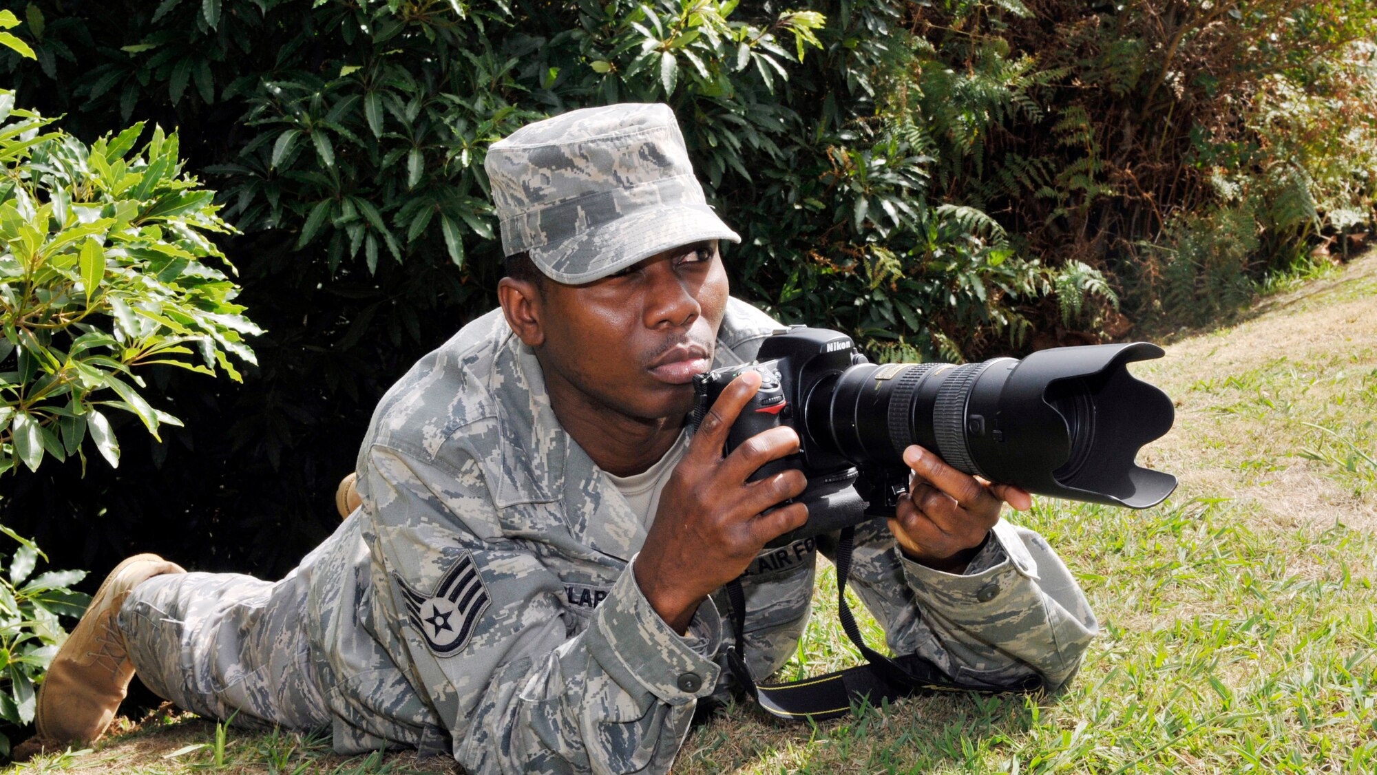 Staff Sgt. Olufemi Owolabi, 65th Air Base Wing Public Affairs journalist, gets set to take a photo at Lajes Field, Azores, Portugal Oct. 1.  Sergeant Owolabi keeps sight of the American Dream despite migrating to the United States with nothing from a poverty and hardship stricken country.  Sergeant Owolabi said joining the U.S. Air Force is a dream come true, and he plan to complement his career by commissioning into the Air Force Medical Service Corps. (U.S. Air Force photo by Eduardo Lima)