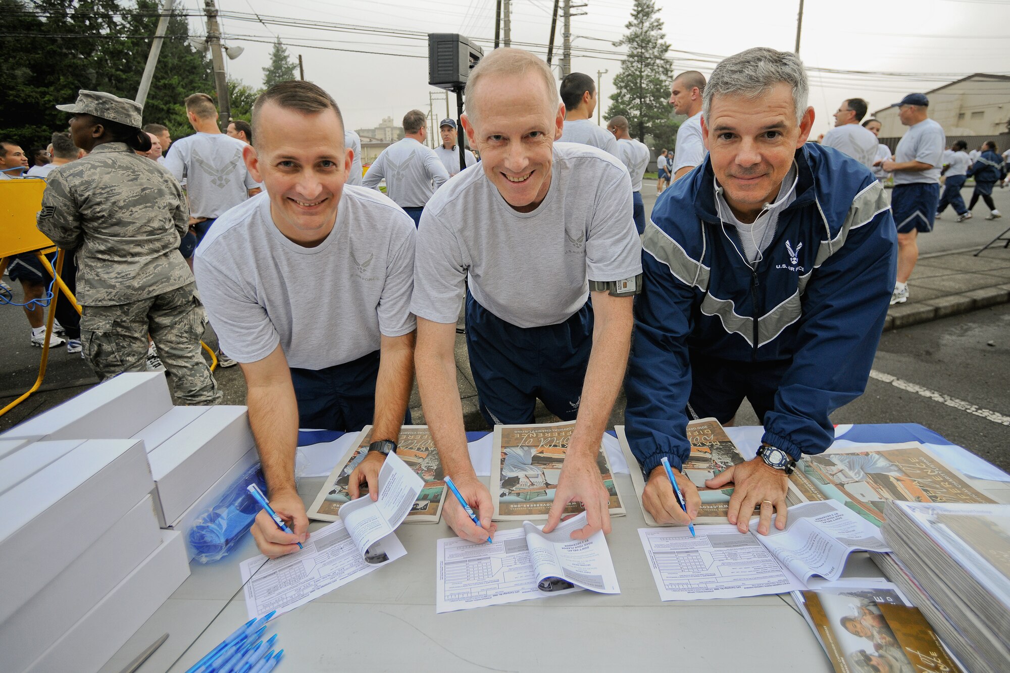 YOKOTA AIR BASE, Japan -- (from left to right) Col. William Knight, 374th Airlift Wing vice commander, Col. Otto Feather, 374th Airlift Wing commander, and Maj. Gen. Salvatore Angelella, Fifth Air Force vice commander, sign their Combined Federal Campaign - Overseas donation cards here Oct. 1 during the weekly Wing Run. The CFC-O is the only authorized solicitation of employees in the federal workplace on behalf of a variety of charitable organizations. The 2010 Yokota CFC-O goal is $300.000. (U.S. Air Force photo/Osakabe Yasuo)