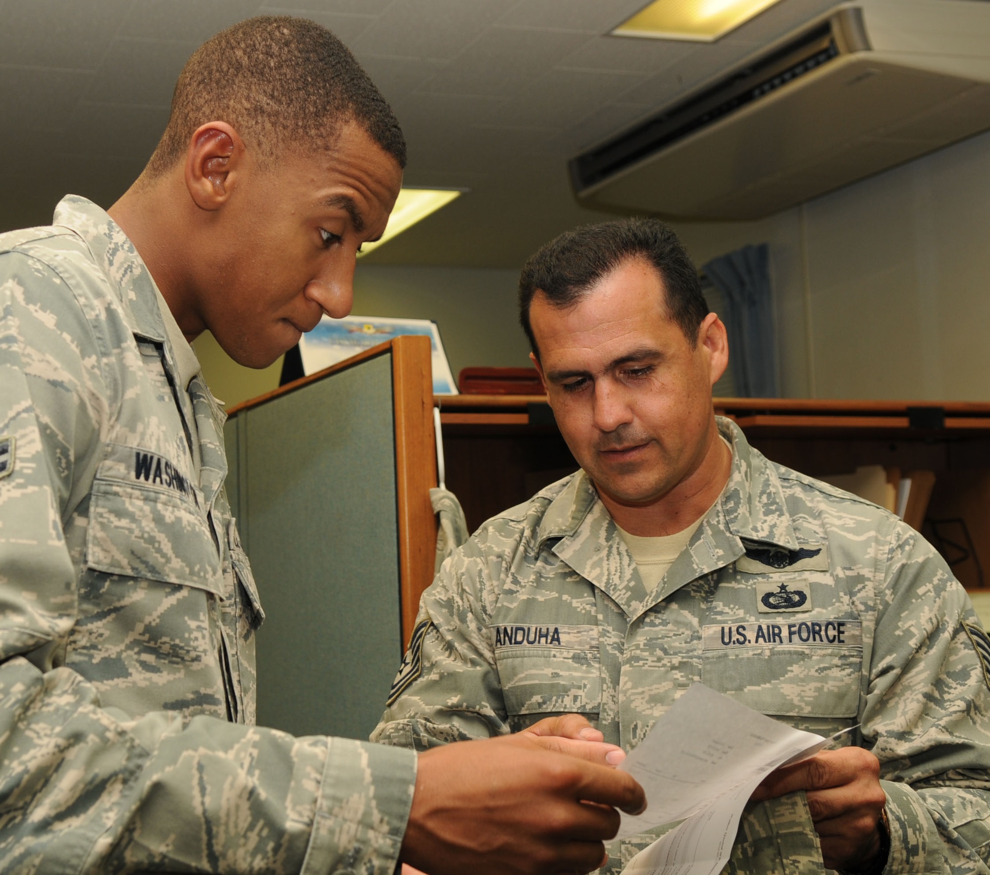 Airman 1st Class Ted Washington, a contracting specialist, works with Tech. Sgt. Manuel Anduha from the 18th Communications Squadron on trying to get a $47,000 purchase before midnight at Kadena Air Base, Japan,  Sept. 30. Members of the 18th Contracting Squadron worked until midnight helping customers get their final purchases before the start of the new fiscal year. (US Air Force photo by Tech. Sgt. Mike Tateishi)