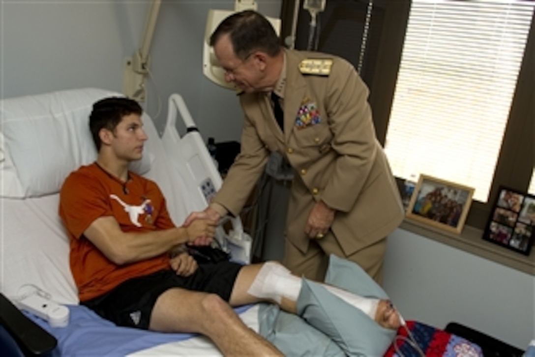 Chairman of the Joint Chiefs of Staff Adm. Mike Mullen, U.S. Navy, presents U.S. Army Spc. David R. Reid III with the Purple Heart during a visit to Brooke Army Medical Center in San Antonio, Texas, on Sept. 30, 2010.  Reid, a Ranger assigned to the 75th Ranger Regiment, sustained his injuries on Sept. 20 when he stepped on a pressure plate improvised explosive device during combat operations in Afghanistan.  