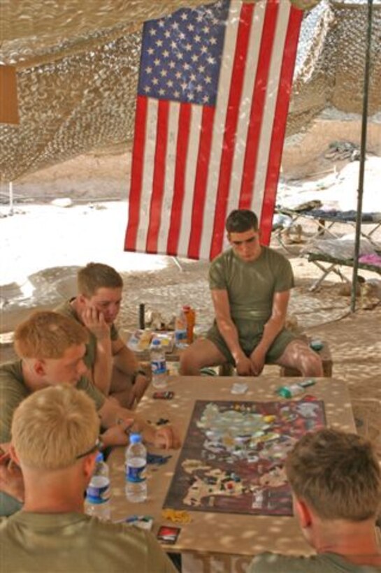 Marines with Company G, Task Force 2/9, play a board game during a break in between patrols at a patrol base in Helmand Province.