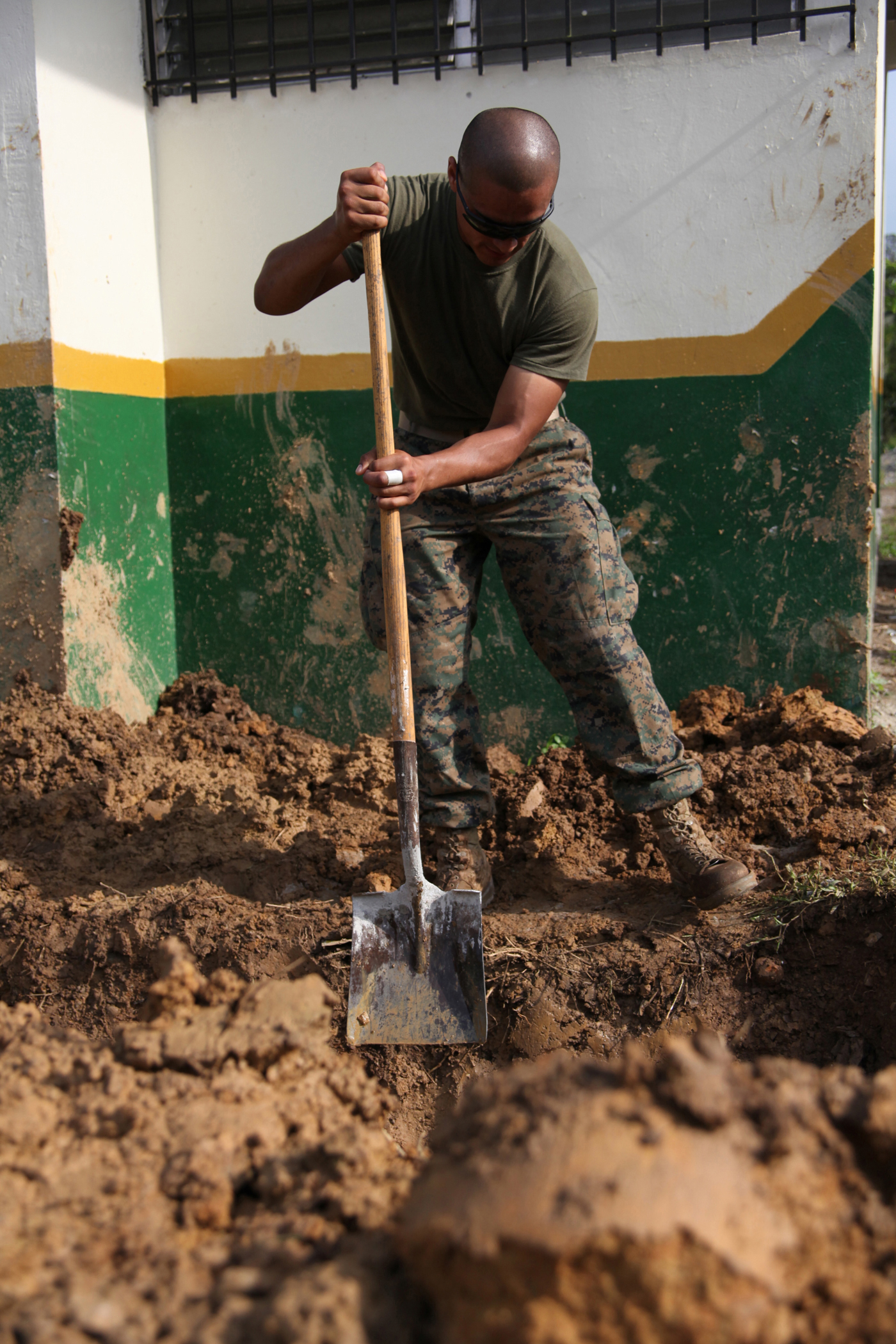 Cpl. Carlos C. Miranda, a heavy equipment operator with 8th Engineer Support Battalion, attached to Special-Purpose Marine Air-Ground Task Force Continuing Promise 2010, digs the sides of a drainage pit at an engineer site in Silico Creek, Panama, Oct. 2, 2010. Marines and sailors of CP10 are anchored off the coast of Chiriqui Grande, Panama, to conduct humanitarian operations. CP10 is a humanitarian civic assistance mission that provides medical, dental, veterinary, engineering support and disaster relief efforts to the Caribbean, Central and South America.