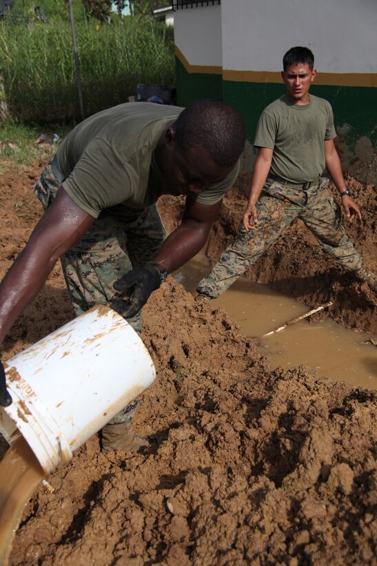 (From left) Lance Cpl. Frantz Rosemond, native of Brooklyn, N.Y., and electrician with 8th Engineer Support Battalion, and Cpl. Byron G. Molina, native of Pembroke Pines, Fla., and combat engineer with 8th ESB, Special-Purpose Marine Air-Ground Task Force Continuing Promise 2010,  fill buckets to remove water for a drainage pit at an engineer site in Silico Creek, Panama, Oct. 2, 2010. Marines and sailors of CP10 are anchored off the coast of Chiriqui Grande, Panama, to conduct humanitarian operations. CP10 is a humanitarian civic assistance mission that provides medical, dental, veterinary, engineering support and disaster relief efforts to the Caribbean, Central and South America.