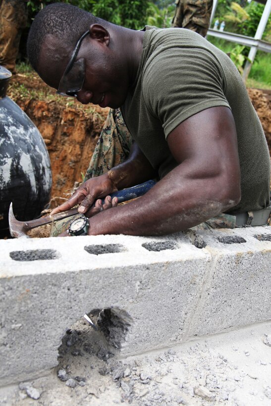 Lance Cpl. Frantz Rosemond, native of Brooklyn, N.Y., and electrician with 8th Engineer Support Battalion, attached to Special-Purpose Marine Air-Ground Task Force Continuing Promise 2010, hammers a hole through cement block for a sewage pipe at an engineer site in Silico Creek, Panama, Oct. 2, 2010. Marines and sailors of CP10 are anchored off the coast of Chiriqui Grande, Panama, to conduct humanitarian operations. CP10 is a humanitarian civic assistance mission that provides medical, dental, veterinary, engineering support and disaster relief efforts to the Caribbean, Central and South America.
