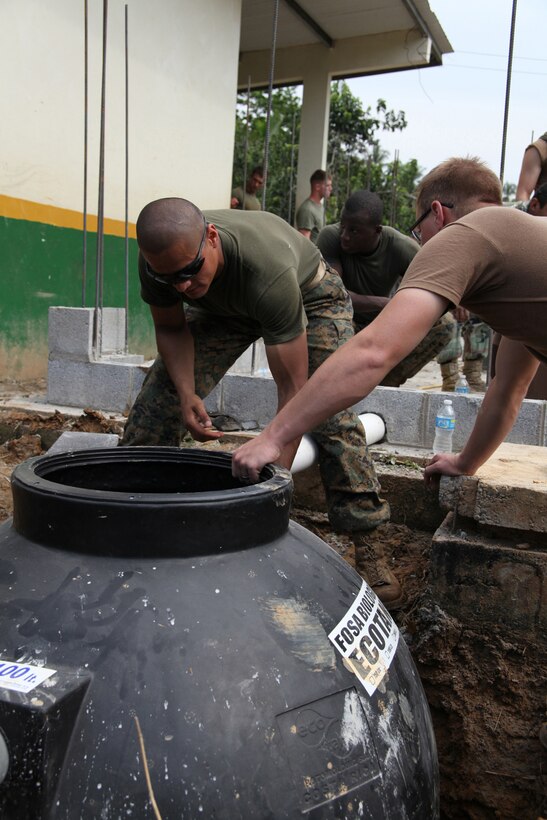 Cpl. Carlos C. Miranda, a heavy equipment operator with 8th Engineer Support Battalion, attached to Special-Purpose Marine Air-Ground Task Force Continuing Promise 2010, and Navy Seabee place a septic tank in the ground at an engineer site in Silico Creek, Panama, Oct. 2, 2010. Marines and sailors of CP10 are anchored off the coast of Chiriqui Grande, Panama, to conduct humanitarian operations. CP10 is a humanitarian civic assistance mission that provides medical, dental, veterinary, engineering support and disaster relief efforts to the Caribbean, Central and South America.