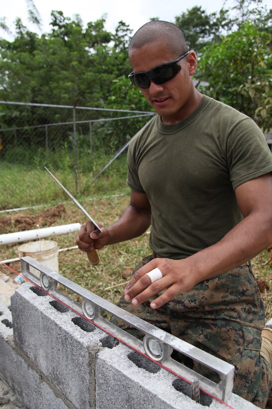 Cpl. Carlos C. Miranda, a heavy equipment operator with 8th Engineer Support Battalion, attached to Special-Purpose Marine Air-Ground Task Force Continuing Promise 2010, checks to see if cement block is level at an engineer site in Silico Creek, Panama, Oct. 2, 2010. Marines and sailors of CP10 are anchored off the coast of Chiriqui Grande, Panama, to conduct humanitarian operations. CP10 is a humanitarian civic assistance mission that provides medical, dental, veterinary, engineering support and disaster relief efforts to the Caribbean, Central and South America.