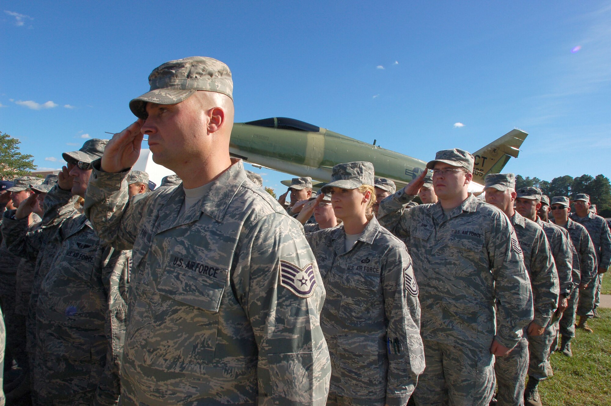 Members of the 103rd Airlift Wing render salutes as the American Flag is lowered and folded for a special 9/11 flag-folding ceremony at the Bradley Air Park, Bradley Air National Guard Base, East Granby, Conn. Sept. 11, 2010. (U.S. Air Force photo by Tech. Sgt. Erin McNamara) 