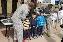 KUNSAN AIR BASE, Republic of Korea -- Staff Sgt. Robert Bradshaw and Senior Airman Evan Bonkofsky, 8th Operations Support Squadron, help Gunsan City school children try on aircrew flight equipment during the Kunsan Air Base Open House and Gunsan Appreciation Day here Oct. 1, 2010. The base opened its doors to the local community and held events including an F-16 Fighting Falcon fly-by, Korean dance performances, static displays, organizational booths, military working dog demonstrations, aircraft munitions-loading competitions, music and more. (U.S. Air Force photo/Senior Airman Ciara Wymbs)