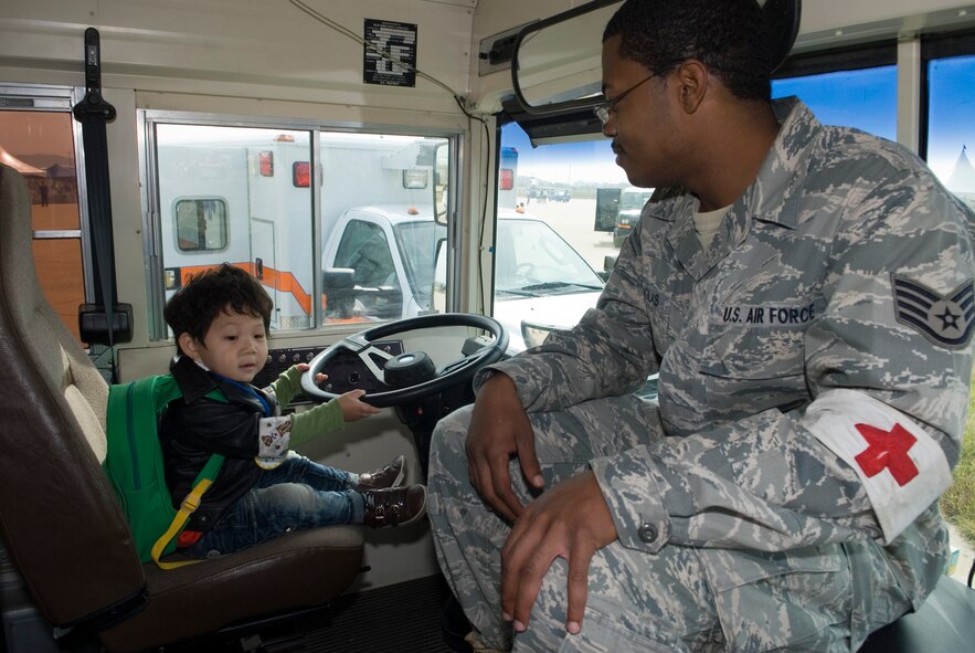 KUNSAN AIR BASE, Republic of Korea -- Staff Sgt. Clarence Douglas, 8th Medical Operations Squadron, watches a young Gunsan City citizen as he pretends to drive a medical bus during the Kunsan Air Base Open House and Gunsan Appreciation Day here Oct. 1, 2010. The base opened its doors to the local community and held events including an F-16 Fighting Falcon fly-by, Korean dance performances, static displays, organizational booths, military working dog demonstrations, aircraft munitions-loading competitions, music and more. (U.S. Air Force photo/Senior Airman Ciara Wymbs)