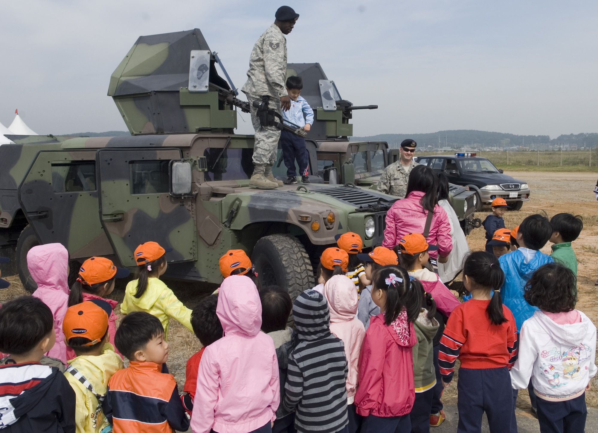 KUNSAN AIR BASE, Republic of Korea -- Staff Sgt. Dion Moore and Lt. Col. Mark Anarumo, 8th Security Forces Squadron, talk to Gunsan City school children during the Kunsan Air Base Open House and Gunsan Appreciation Day here Oct. 1, 2010. The base opened its doors to the local community and held events including an F-16 Fighting Falcon fly-by, Korean dance performances, static displays, organizational booths, military working dog demonstrations, aircraft munitions-loading competitions, music and more. (U.S. Air Force photo/Senior Airman Ciara Wymbs)