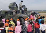 KUNSAN AIR BASE, Republic of Korea -- Staff Sgt. Dion Moore and Lt. Col. Mark Anarumo, 8th Security Forces Squadron, talk to Gunsan City school children during the Kunsan Air Base Open House and Gunsan Appreciation Day here Oct. 1, 2010. The base opened its doors to the local community and held events including an F-16 Fighting Falcon fly-by, Korean dance performances, static displays, organizational booths, military working dog demonstrations, aircraft munitions-loading competitions, music and more. (U.S. Air Force photo/Senior Airman Ciara Wymbs)