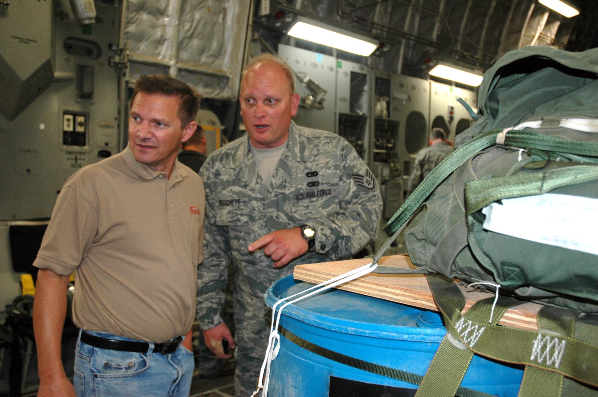 JOINT BASE LEWIS-MCCHORD, Wash.- Staff Sgt. Michael Pritchett, right, a ramp specialist with the 36th Aerial Port Squadron, describes how he loads and unloads cargo to his civilian supervisor, Jim Klienstuber, a manager with Frontier Communications in Oregon.  Civilian employers from the Northwest region had an opportunity to spend a day with their Reservists learning about their Air Force mission during the bi-annual Employer Orientation Day here on Oct. 2. (U.S. Air Force photo/Staff Sgt. Elizabeth Moody)