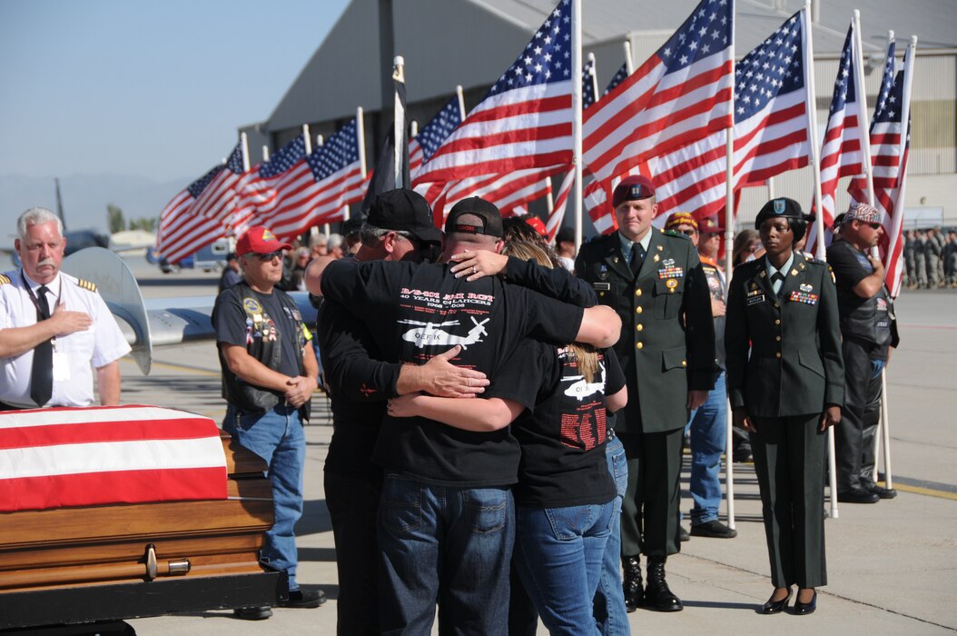 The family of Chief Warrant Officer 3 Matthew G. Wagstaff hugs near his casket shortly after his remains arrived at the Utah Air National Guard base in Salt Lake City, Utah, on October 3, 2010. CW3 Wagstaff was a UH-60 Blackhawk pilot who died in Afghanistan September 21. He was serving on his third deployment at the time. (U.S. Air Force photo by Master Sergeant Gary J. Rihn)(RELEASED)
