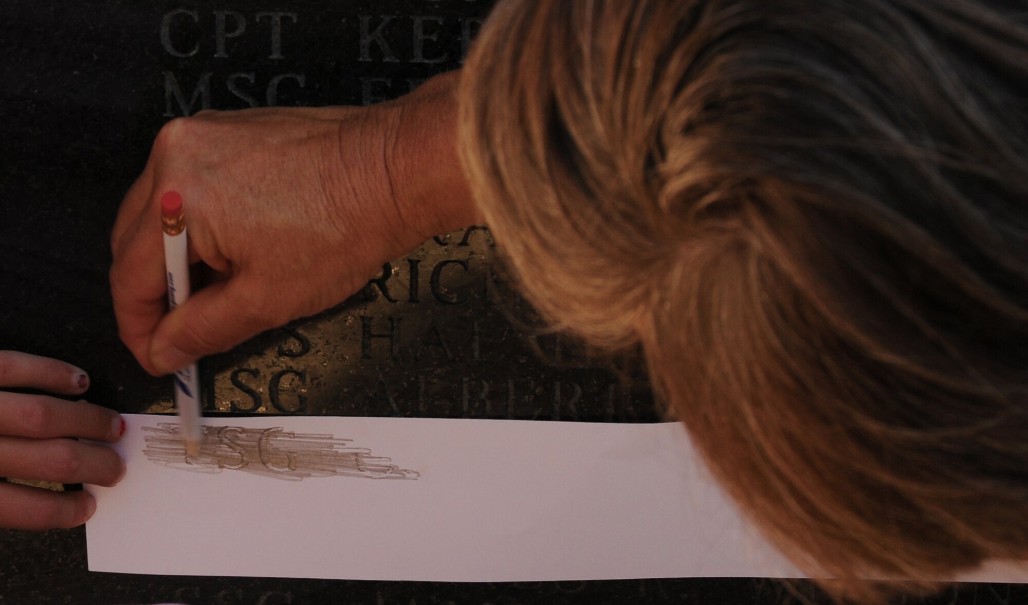 Charlotte, N.C. -- Relatives of deceased airmen of the North Carolina Air National Guard from the past year etch names from the memorial statue onto a keepsake paper after attending a memorial service. (NCANG photo by Tech. Sgt. Rich Kerner)
