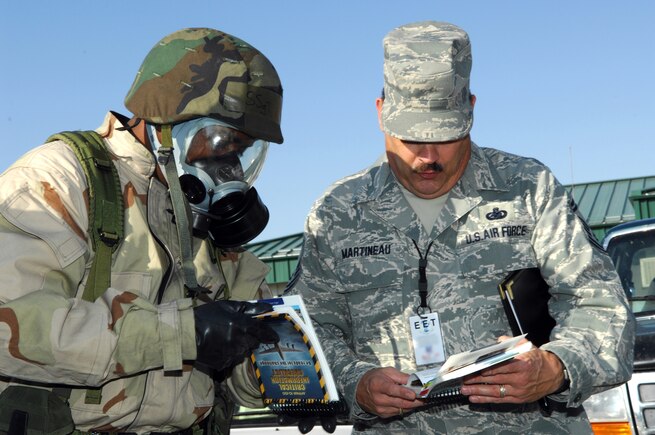 Exercise Evaluation Team member Senior Master Sgt. Allan Martineau critiques Staff Sgt. Shawn Davies, 151st Logistics Readiness Squadron, on his response as a Post Attack Reconnaissance (PAR) team member to a contaminated area during an Ability To Survive and Operate (ATSO) exercise at the Utah Air National Guard Base in Salt Lake City, Utah.  (U.S. Air Force photo by Tech. Sgt. Kelly K. Collett)(RELEASED)