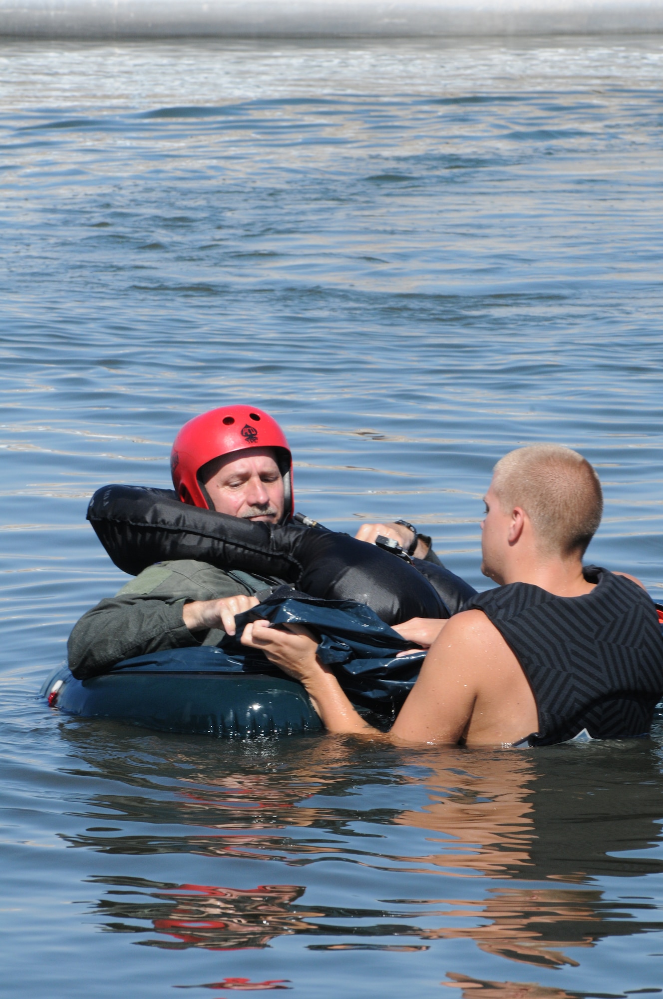 Senior Airman Bo Martz reviews the one-man liferaft with Col. Mathew Jamison during Survival training at Brant Lake, S.D., Aug. 8 2010. (Air Force Photo by Master Sgt. Christopher Stewart, 114th Fighter Wing)