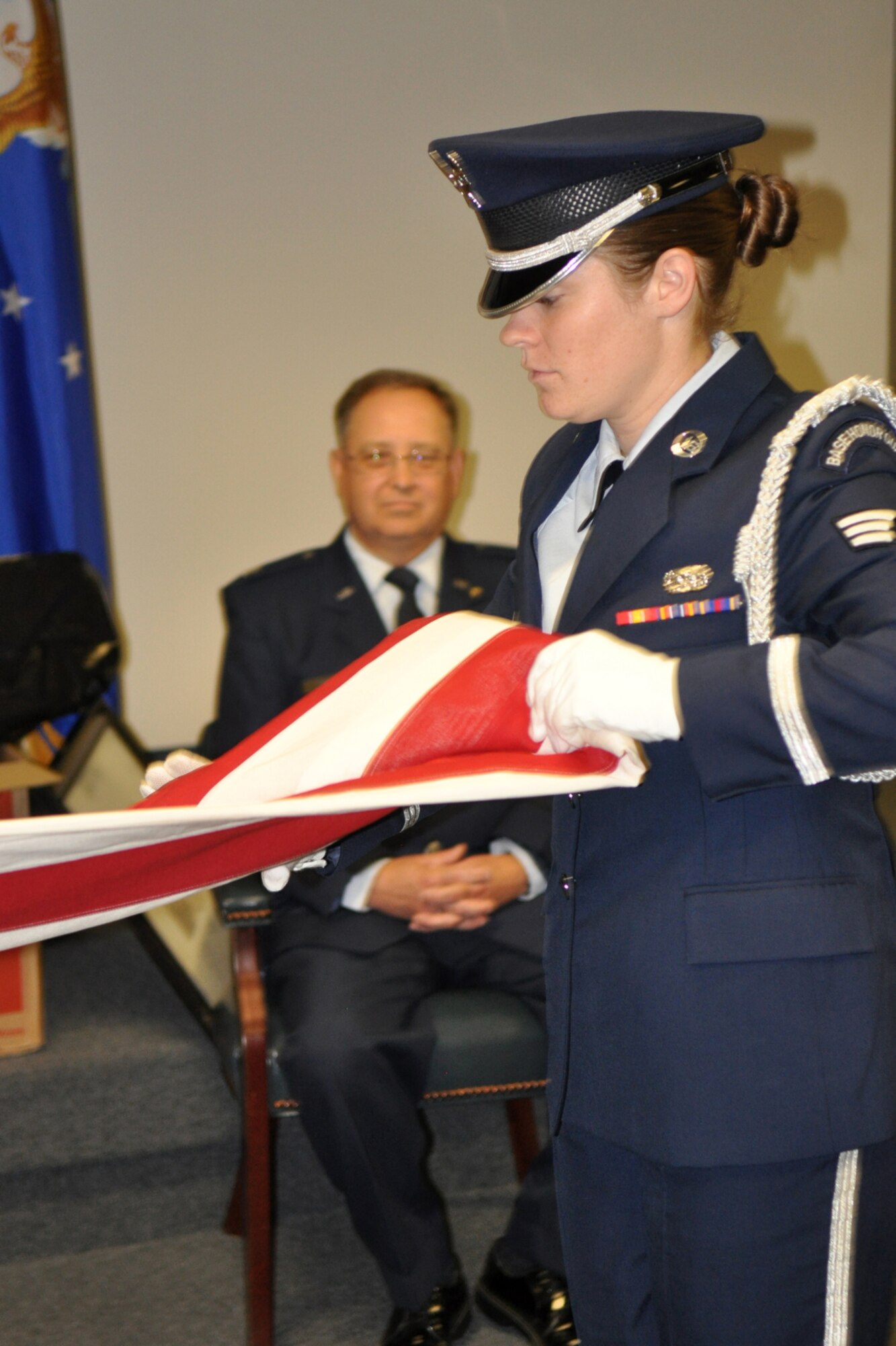 Lt. Col. Donald Moton, 917th Mission Support Group Deputy commander watches as the Barksdale Honor Guard performs a flag folding on the occasion of his retirement Oct. 2, 2010 in the 917th Wing auditorium, Barksdale AFB, La.  Colonel Moton received the Meritorious Service Medal during the ceremony celebrating his 40 years of military service with the 917th Wing. (U.S. Air Force Photo/Senior Master Sgt. Jessica Daurizio)