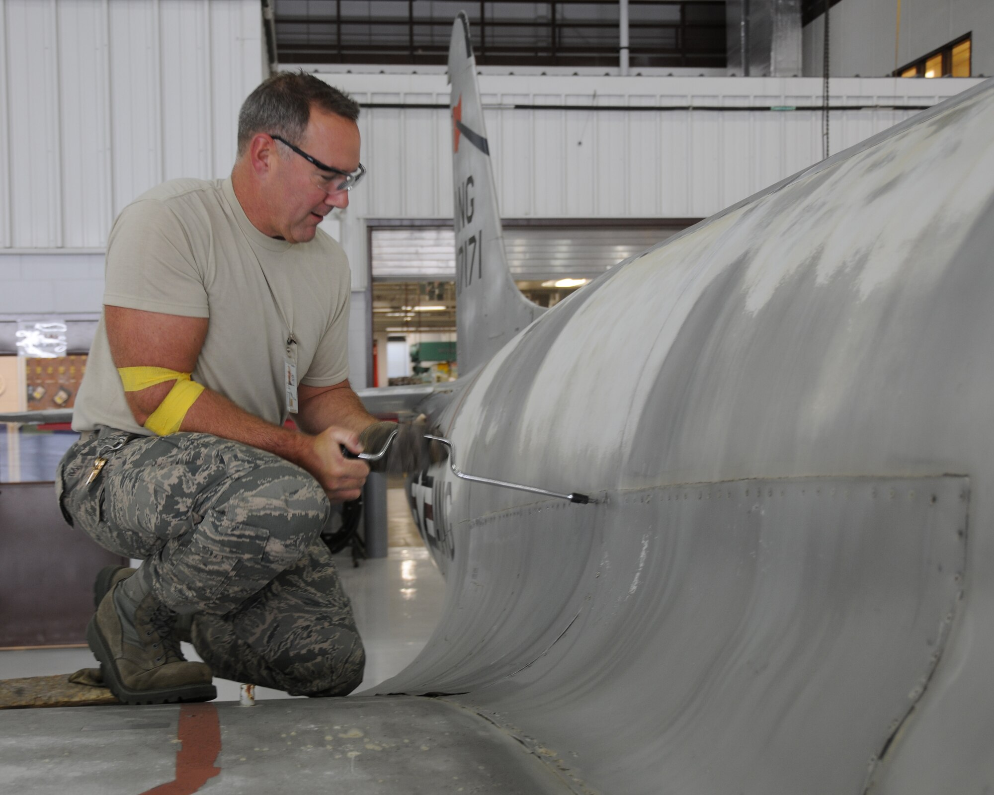Senior Master Sgt. Don Leget, 185th Air Refueling Wing Fabrication Element, Sioux City, Iowa, removes a wing fairing from an F-80 in an early step of the restoration process. The F-80C was flown at the 185th from July 1953 through 1955 and is being restored as a static display to showcase the unit's history.