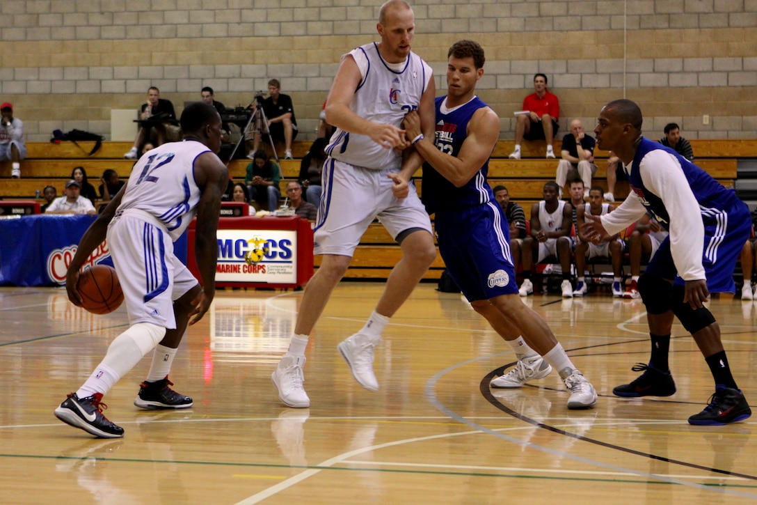 Eric Bledsoe, guard, Los Angeles Clippers, dribbles the ball down the court as Chris Kaman, center, blocks Blake Griffin during a scrimmage game at Marine Corps Base Camp Pendleton’s Paige Field house, Oct. 3. The team offered a free open practice for service members and their families.