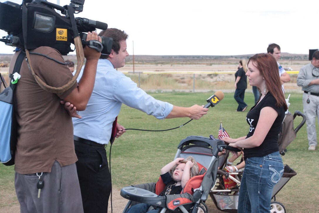 Cheyenne Williams, wife of Cpl. Joshua Williams, a radio operator for Regimental Combat Team 7, does an interview with Mike Daniels, a reporter with KESQ TV, during the homecoming of RCT-7 main body Oct. 4, 2010, at Del Valle Field. ::r::::n::
