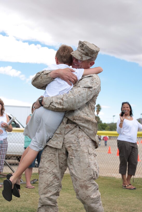 Colonel Randy Newman, the commanding officer of Regimental Combat Team 7, hugs his 8-year-old son after a yearlong deployment to Helmand province, Afghanistan, during the homecoming of RCT-7’s main party Oct. 4, 2010 at Del Valle Field.