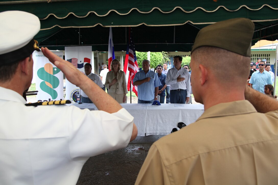 Navy Capt. Thomas J. Chassee, commanding officer of USS Iwo Jima and Lt. Col. Chris S. Richie, commanding officer of Special-Purpose Marine Air-Ground Task Force Continuing Promise 2010, salute the national ensign during the playing of the U.S. national anthem at a presidential visit in Punta Pena, Oct. 4. Marines, sailors, soldiers, airmen, civilians and Panamanian citizens attended a visit by Panamanian President Ricardo Martinelli, Vice President Juan Carlos Varela; Phyllis M. Powers, U.S. ambassador to Panama; and Franklin Vergara, Panama’s minister of health. CP10 personnel are anchored off the coast of Chiriqui Grande, Panama, to conduct humanitarian operations to the Caribbean, Central and South America.