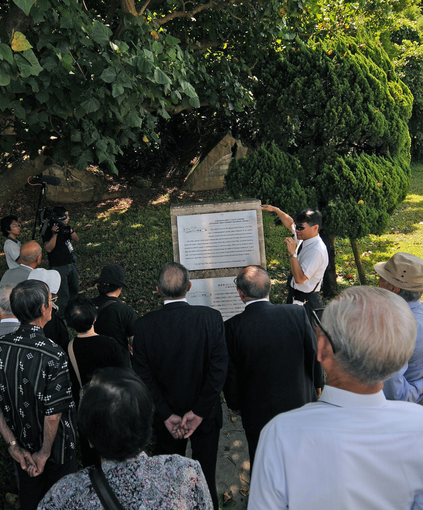 (Center) Hideaki Sakihama, 18th Wing Public Affairs community relations specialist, explains the significance of one of Kadena Air Base's historic sites near Gate 3 during a tour with Japanese World War II era veterans and families Sept. 30. Nearly 30 members from various branches of Japan's Disabled Veterans Association visited the base's old kamikaze aircraft hangars and Peace Garden - the site where the Japanese 10th Army surrendered at the end of the war. (Air Force/Tech. Sgt. Jason Lake)
