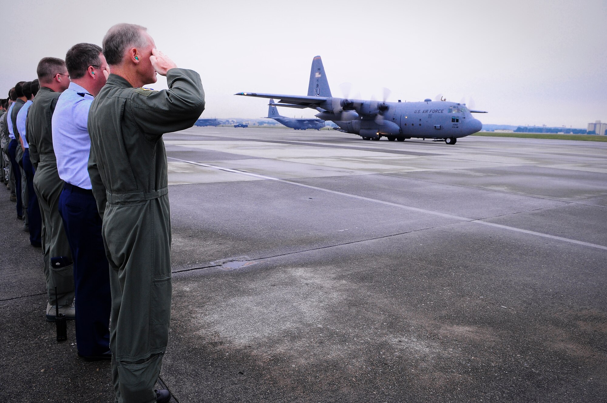 YOKOTA AIR BASE, Japan -- Col. Otto Feather, 374th Airlift Wing commander, along with other members from the 374 AW render a farewell salute to the departing C-130 Hercules, Oct 4. Wing leaders, friends and families came out to show support for several members from the 36th Airlift Squadron and 374th Maintenance Group as they departed for a deployment to Southwest Asia. (U.S. Air Force photo/Staff Sgt. Stacy Moless)