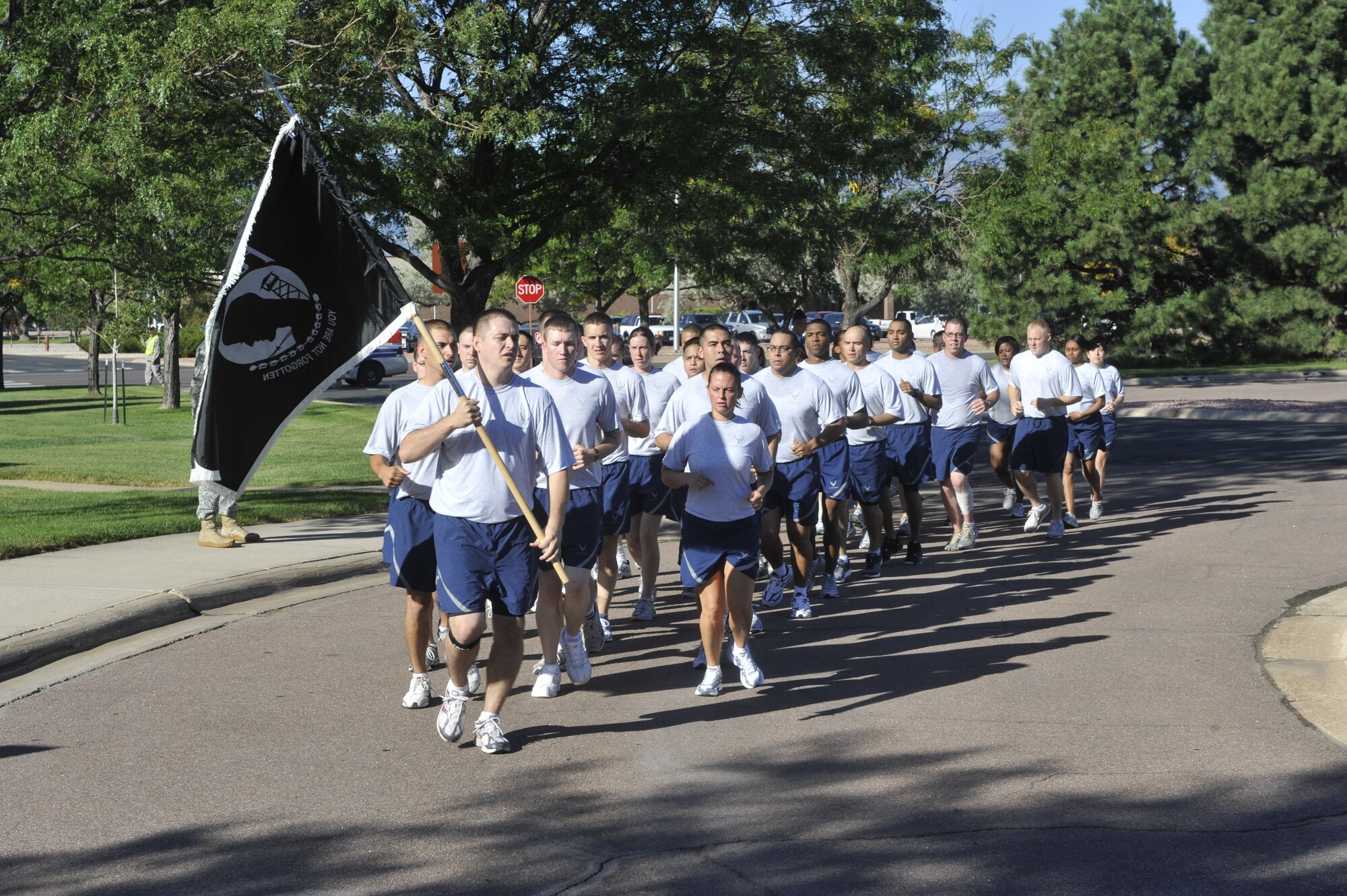 PETERSON AIR FORCE BASE, Colo. – The Airman Leadership School class 10-7 and staff carry a Prisoner of War/Missing In Action flag Sept. 17 to the Peterson Chapel during a ceremony to commemorate the national POW/MIA Remembrance Week. Peterson Airmen held a 24-hour POW/MIA run, with the ALS class and staff running the final leg, ending the run at the ceremony where they placed the POW/MIA flag center stage. (U.S. Air Force photo/Robb Lingley)