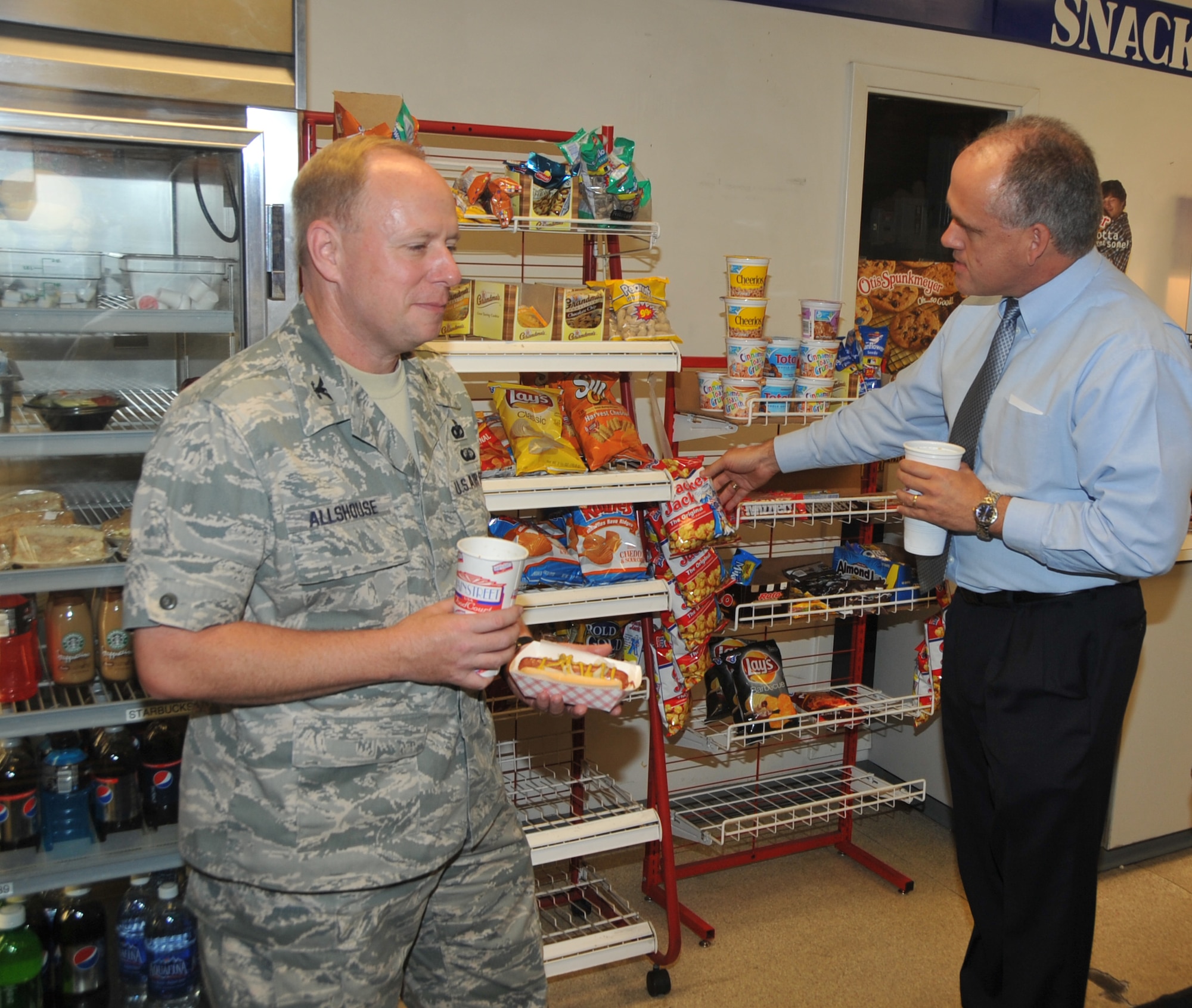 OFFUTT AIR FORCE BASE, Neb. - Col. Michael Allshouse, 55th Mission Support Group commander, and John Kundinger, 55th Mission Support Group deputy director, enjoy one last trip to D's Dog Stand in the Martin Bomber Building Sept. 30. After 69 years of service, the hot dog stand closed its doors, leaving behind a legacy of satisfied customers and life-long relationships. U.S. Air Force photo by Jeff Gates