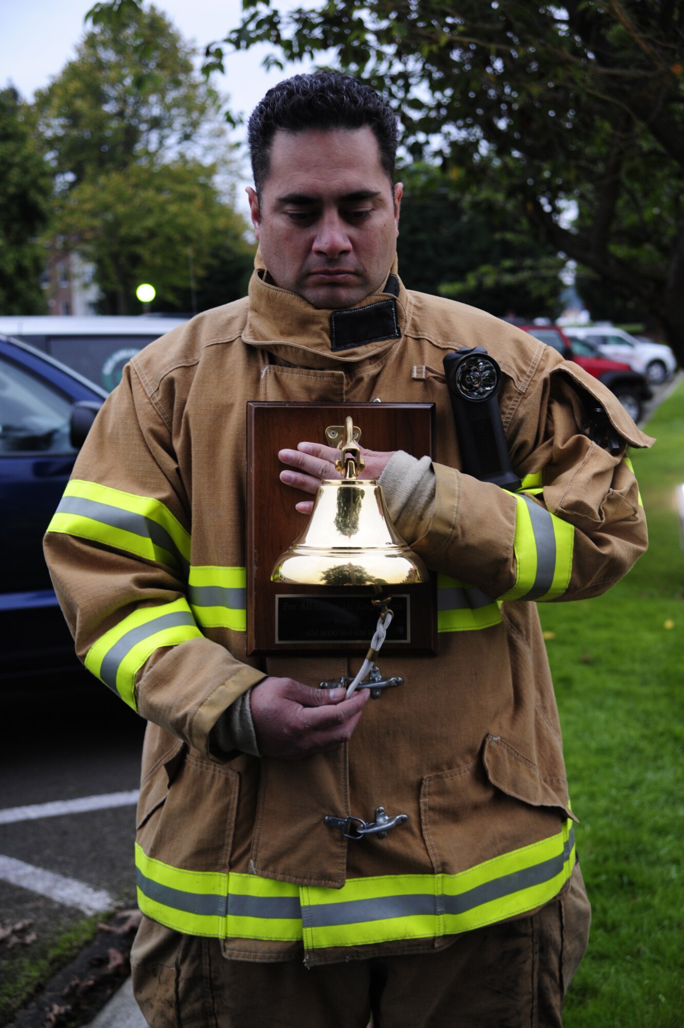 Tech. Sgt. Tanner Scanlan, 627th Air Base Group firefighter, rings a bell to remember fallen firefighters during a ceremony in honor of National Fallen Firefighters Memorial Weekend Oct. 3 at Joint Base Lewis-McChord, Wash. (U.S. Air Force Photo/Airman Leah Young)