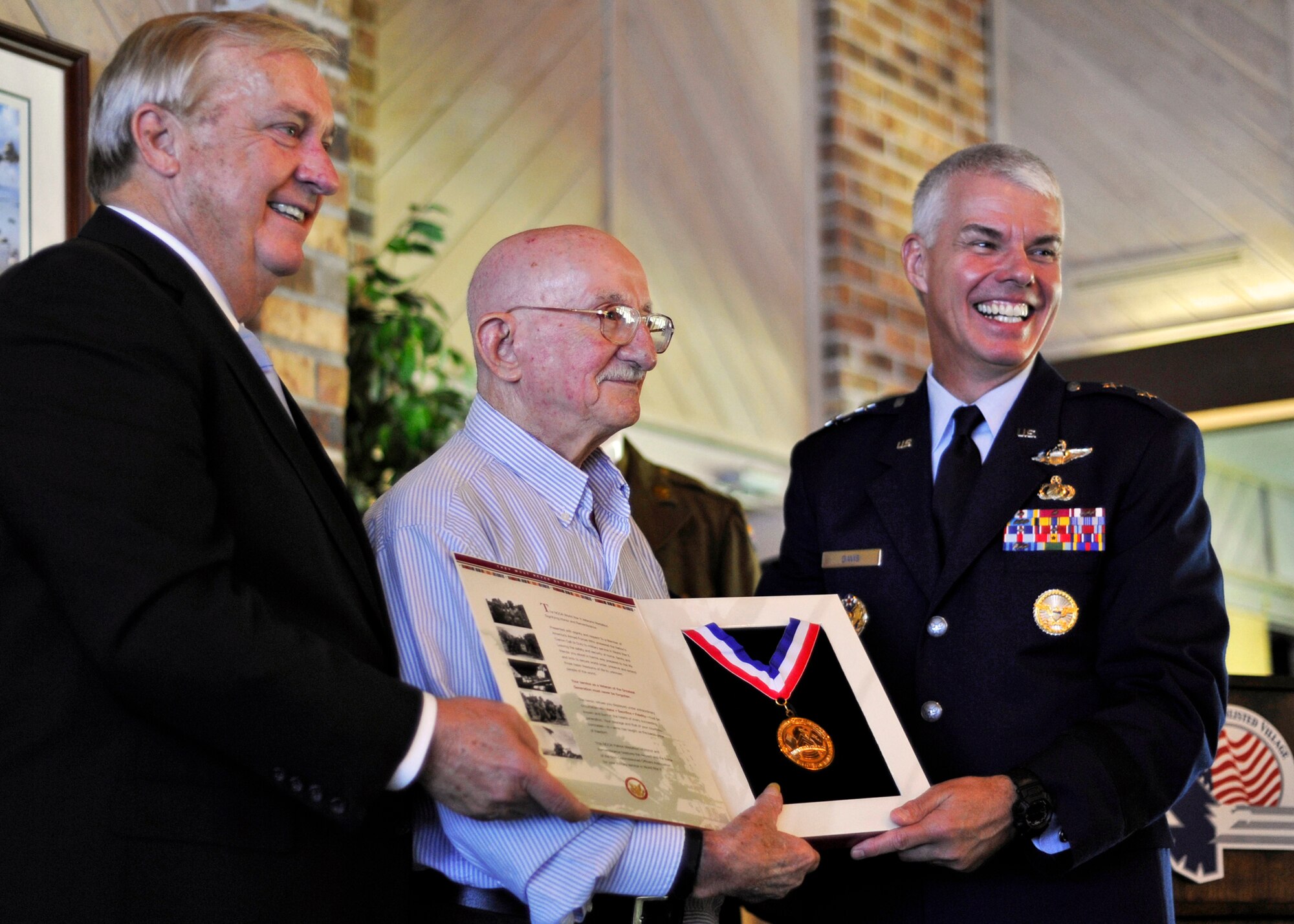 Richard Butt, Army Air Corps and Air Force from 1942-63, receives a Patriot Medallion of Honor and Remembrance during a ceremony Sept. 30 at the Air Force Enlisted Village.  Also pictured, former Chief Master Sgt. of the Air Force, James Binnicker and Maj. Gen. C.R. Davis, Air Armament Center commander.  (U.S. Air Force photo/Samuel King Jr.)
