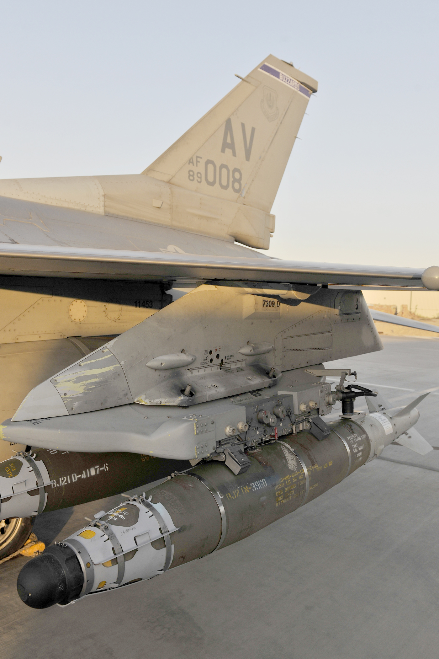 bomb hanging beneath the wing of a plane