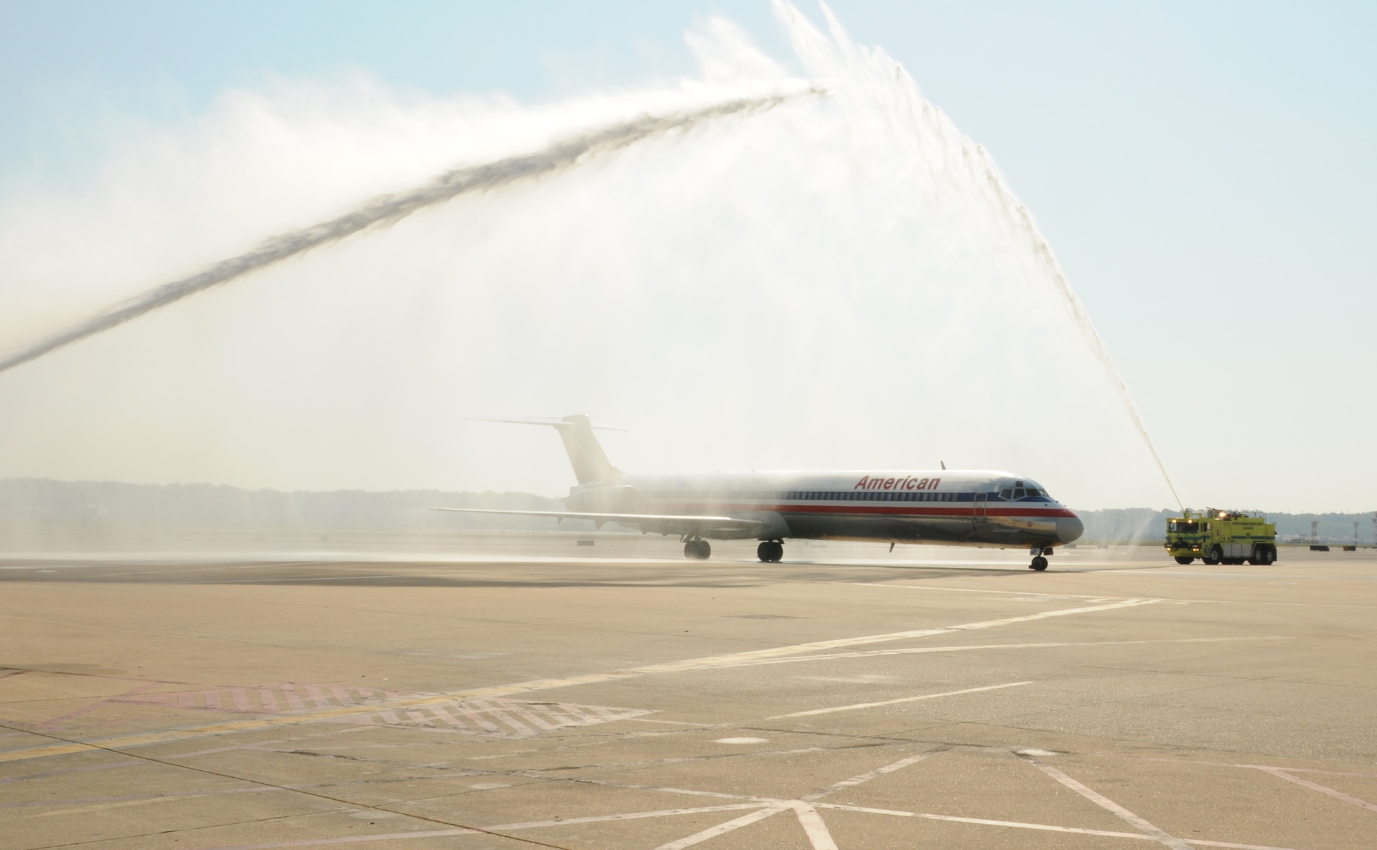 REAGAN NATIONAL AIPORT, Va. -- A chartered airline carrying WWII veterans from the Honor Flight Network arrives at Reagan National Airport, Va., under an arch of water being sprayed from two aiport fire trucks here Sept. 22. The spraying of water was part of a traditional greeting, honoring the veterans for the sacrifices they made defending the nation during WWII. (U.S. Air Force photo/Tech. Sgt. Steve Lewis)