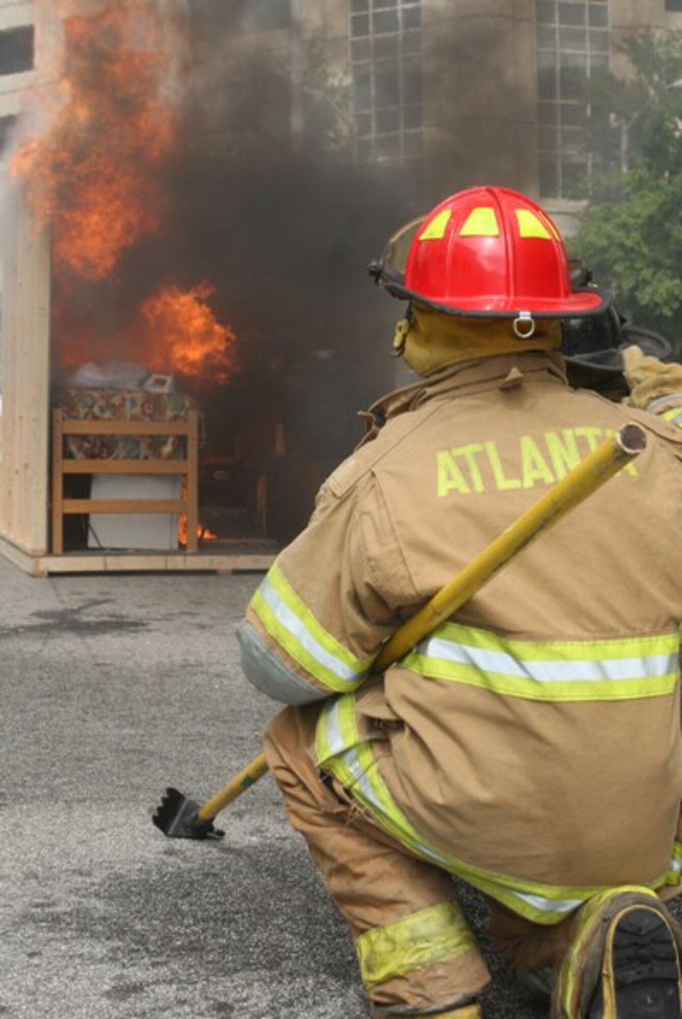 Firefighters from Dobbins and the City of Atlanta start fires in two mock dormitory rooms, one with and one without sprinkler systems to demonstrate how fast fires spread and how valuable sprinklers are. The demonstration was a part of a fire safety awareness program sponsored by the University of Georgia, Atlanta, Ga., Sept. 30. (U.S. Air Force Photo/Don Peek)