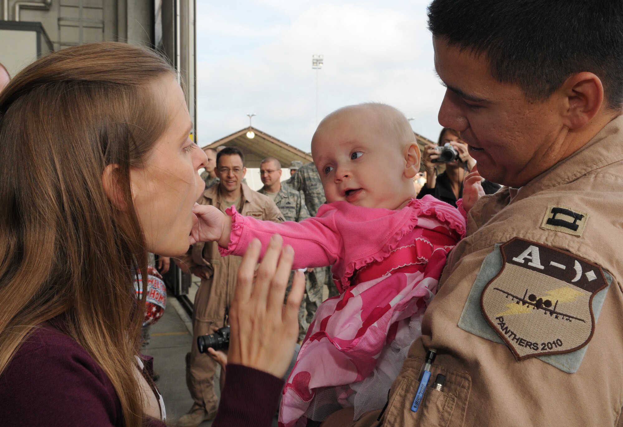 SPANGDAHLEM AIR BASE, Germany – Capt. Josh Arrowood, right, 81st Fighter Squadron pilot, greets his new baby, Annebelle, and wife, Jackie, as he returns from a deployment Oct. 1. Captain Arrowood was deployed for five months to Kandahar, Afghanistan. (U.S. Air Force photo/Staff Sgt. Wilson)