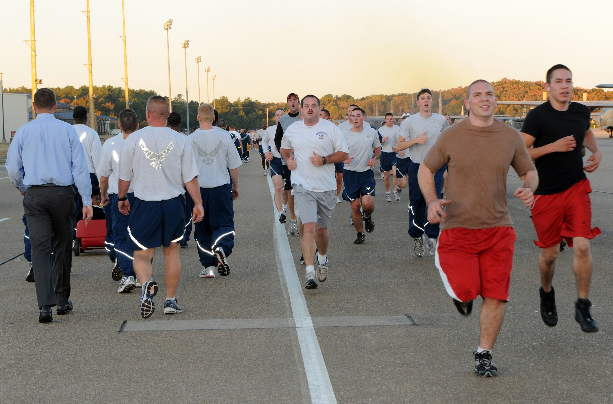 Base personnel and their families run and walk along flight line road Oct. 1 during the wing fun run. Family members of all ages joined the run and brought their children in strollers and wagons. (Courtesy photo by Ashley Mangin)