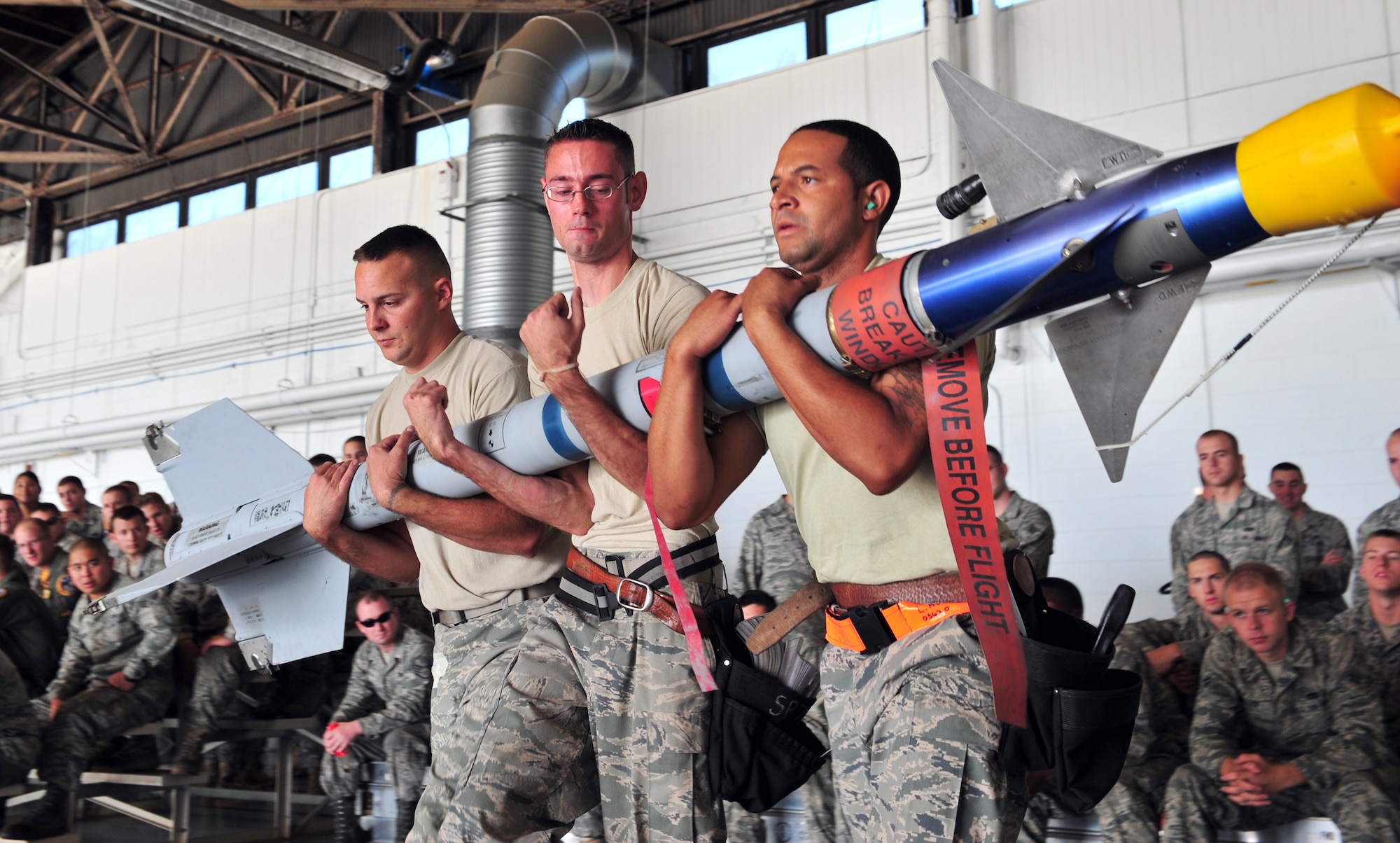 101001-F-8430J-056
SHAW AIR FORCE BASE, S.C. -- Airman 1st Class Eric Sgarlata (left), Staff Sgt. Josh Humphrey (center) and Airman 1st Class Lecedric Hester (right), 79th Aircraft Maintenance Unit, move a missile to load it onto an F-16 Oct. 1, 2010. Wing weapons standardization held the third Weapons Load Crew of the Quarter Competition for 2010. The 55th and 79th Aircraft Maintenance Units Weapons load crews competed against each other in a race against time. Both load crews were tasked to load two F-16s with weapons within 45 minutes.  (U.S. Air Force photo/Airman 1st Class Amber E. N. Jacobs (Released))