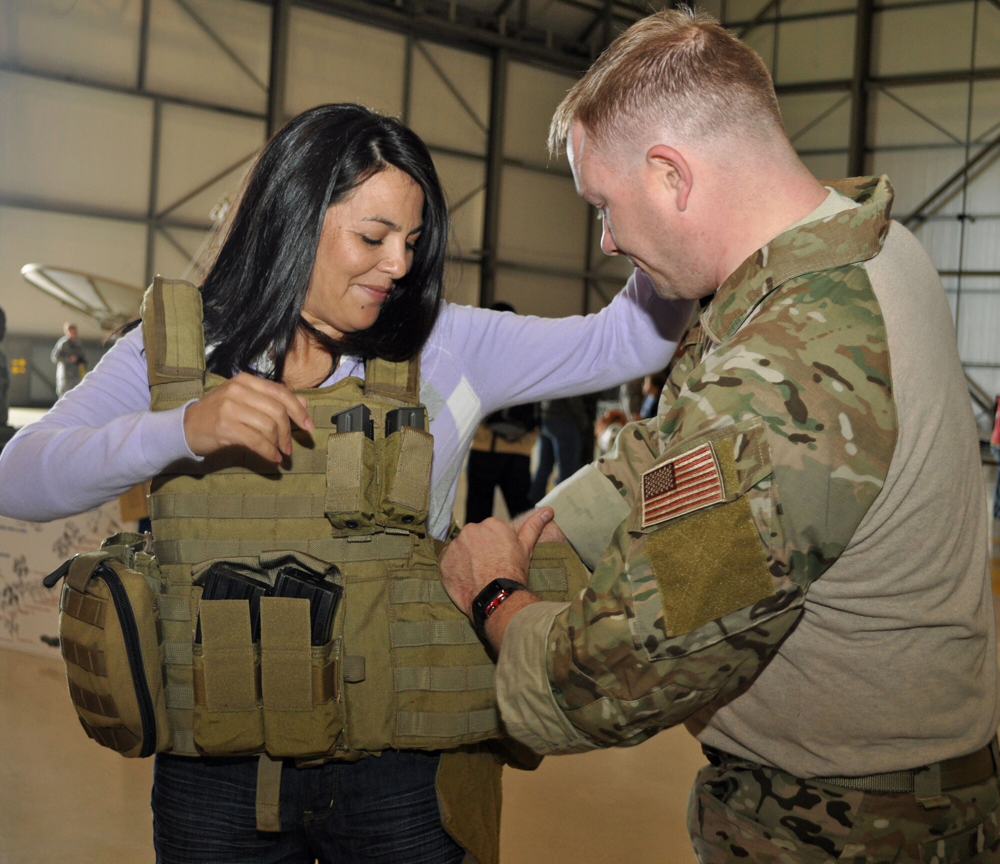 RAF MILDENHALL, England – Mrs. Sandra Gill, wife of Capt. Grant Gill assigned to the 352nd Special Operations Maintenance Squadron, gets fitted for a flak vest by a special operations weatherman during recent Spouses Day activities.  Vests, such as this one, were one of many items displayed by the 321st Special Tactics Squadron.  Other units from the 352nd SOG as well the Joint Special Operations Air Component – Europe provided displays and gave briefings to the over 100 family members who were present.  (U.S. Air Force photo/Tech. Sgt. Marelise Wood)