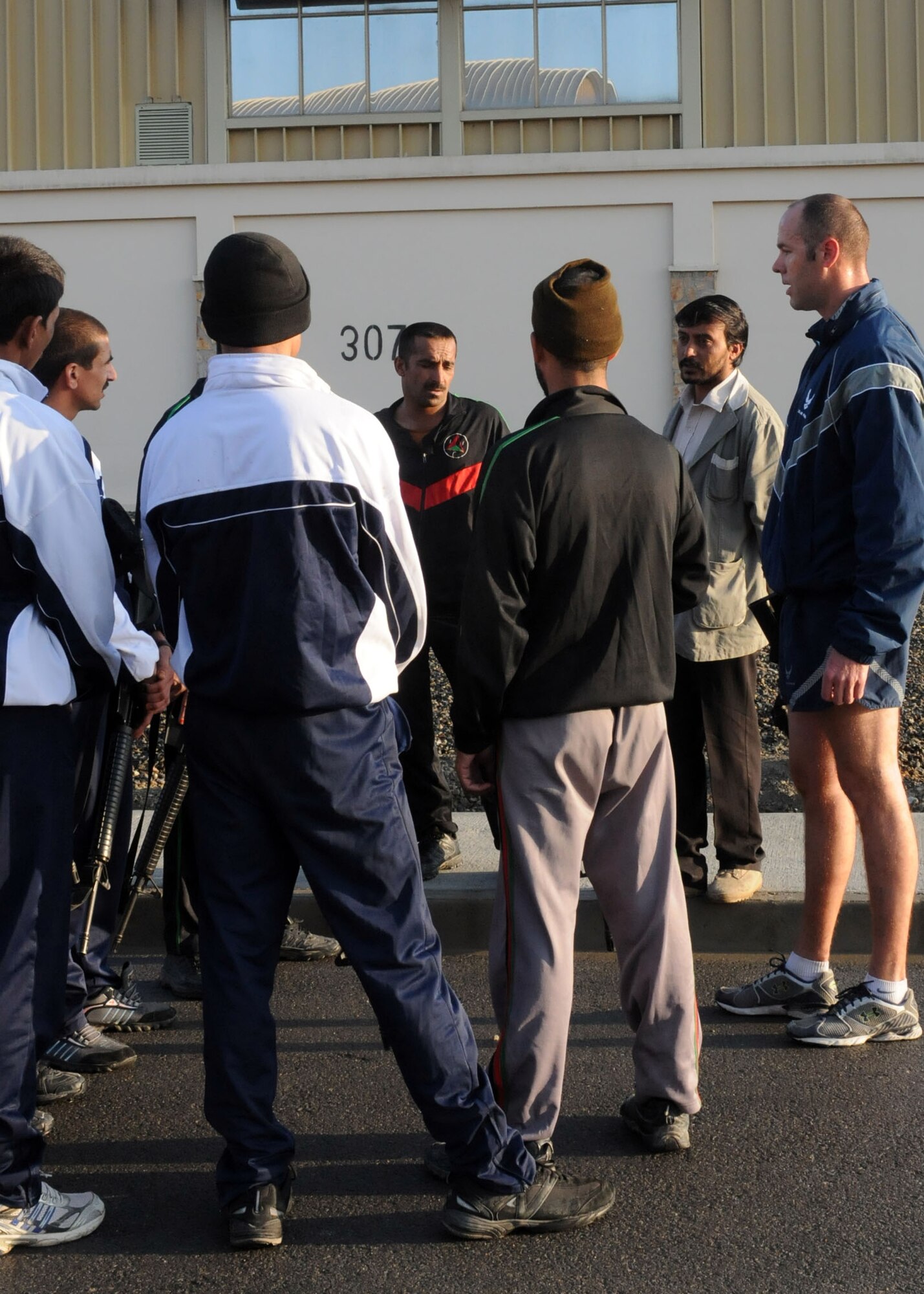 Members of the Afghan Air Force Security Force engage in physical fitness with NATO Air Training Command - Afghanistan advisor, Capt. Robert Shaw on Sept 30, 2010.  (U.S. Navy photo by MC3 Jared Walker/RELEASED).