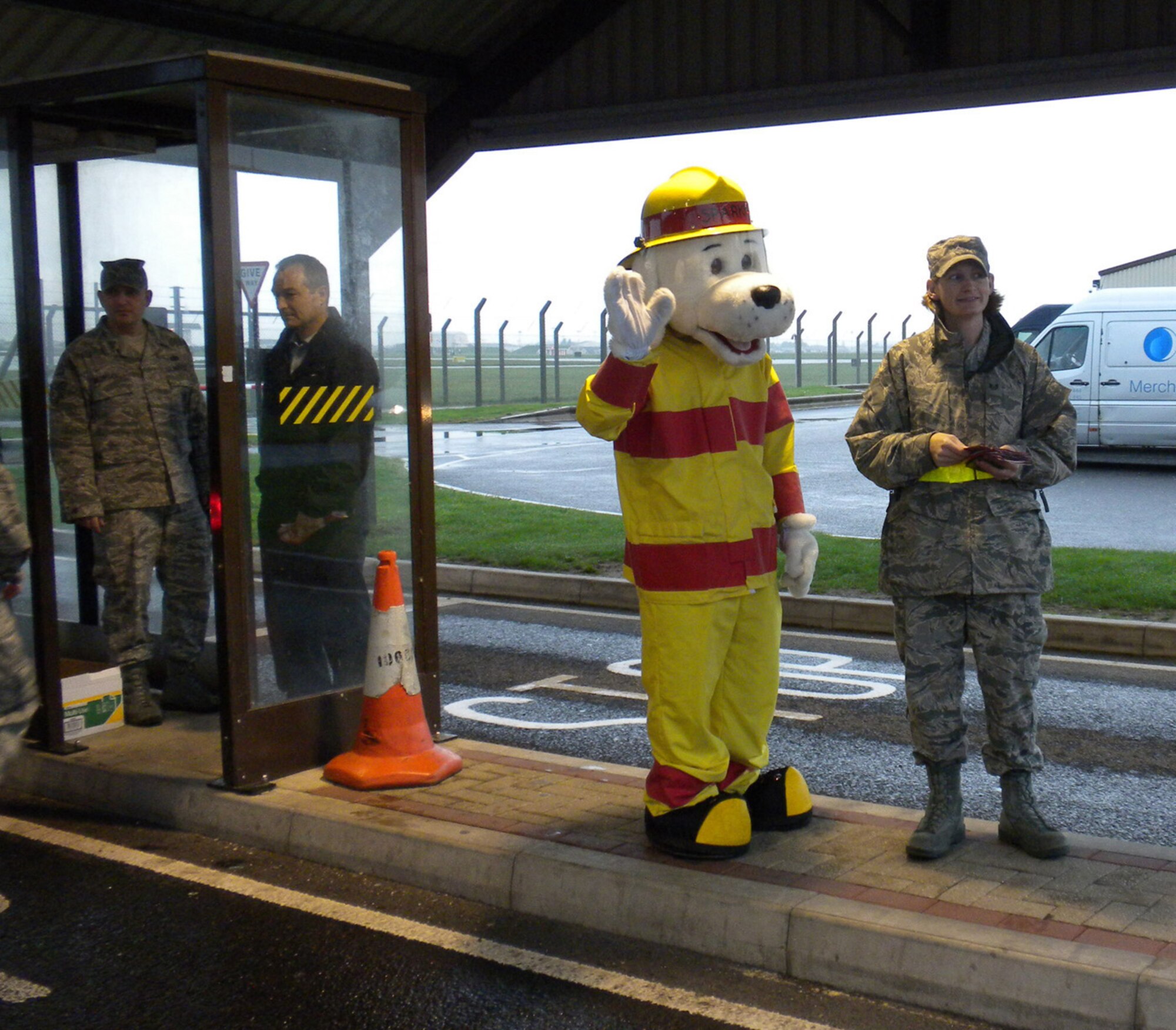 RAF MILDENHALL, England -- Sparky the Fire Dog and his coworkers from the 100th Civil Engineer Squadron Fire Department greet RAF Mildenhall members at the main gate ID checkpoint Oct. 4, and hand out leaflets to mark the start of Fire Prevention Week. There are events going on all week, finishing with an Open House at the fire department Oct. 9 from 11 a.m. to 3 p.m. (U.S. Air Force photo/Karen Abeyasekere)                  