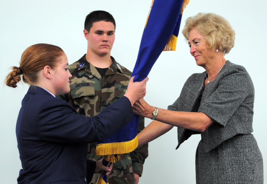 YOKOTA AIR BASE, Japan -- Cadet Major Chelsea Northcutt, Yokota Junior Reserve Officer Training Corps commander, receives the guidon from Diana Ohman, DoDDS-Pacific director, during a change of command ceremony here Sept. 22. The change of command marked the change from the Army JROTC program at Yokota High School to the Air Force JROTC program as well as the change of a new commander. (U.S. Air Force Photo/Airman 1st Class Katrina R. Menchaca)