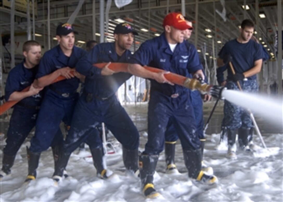 U.S. Navy sailors wash down the deck aboard the amphibious assault ship USS Makin Island (LHD 8) after an aqueous film-forming foam systems check while underway off the coast of southern California on Sept. 29, 2010.  The Makin Island is conducting pre-inspection checks in preparation for a special trials inspection.  